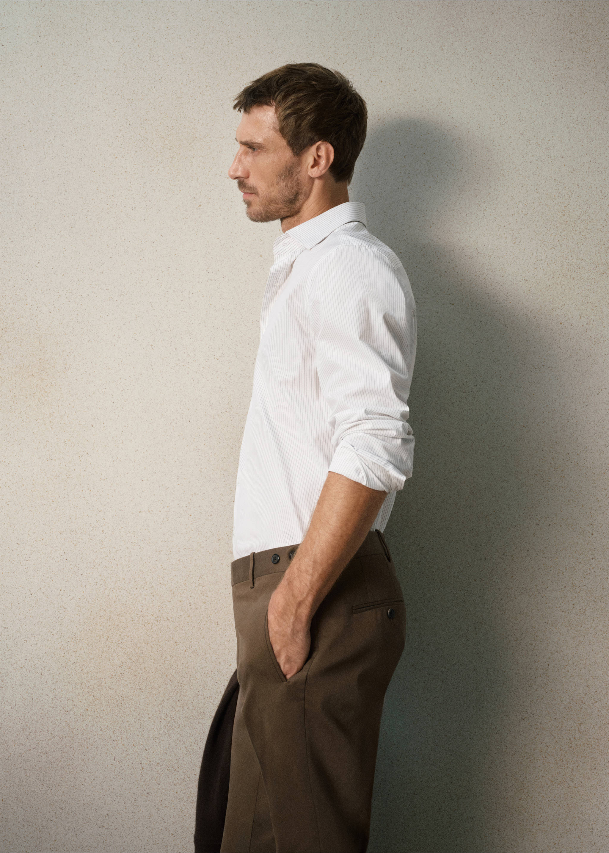 White pinstriped long-sleeved shirt with a classic collar, worn with brown trousers., White. Ref: 37067938-00.