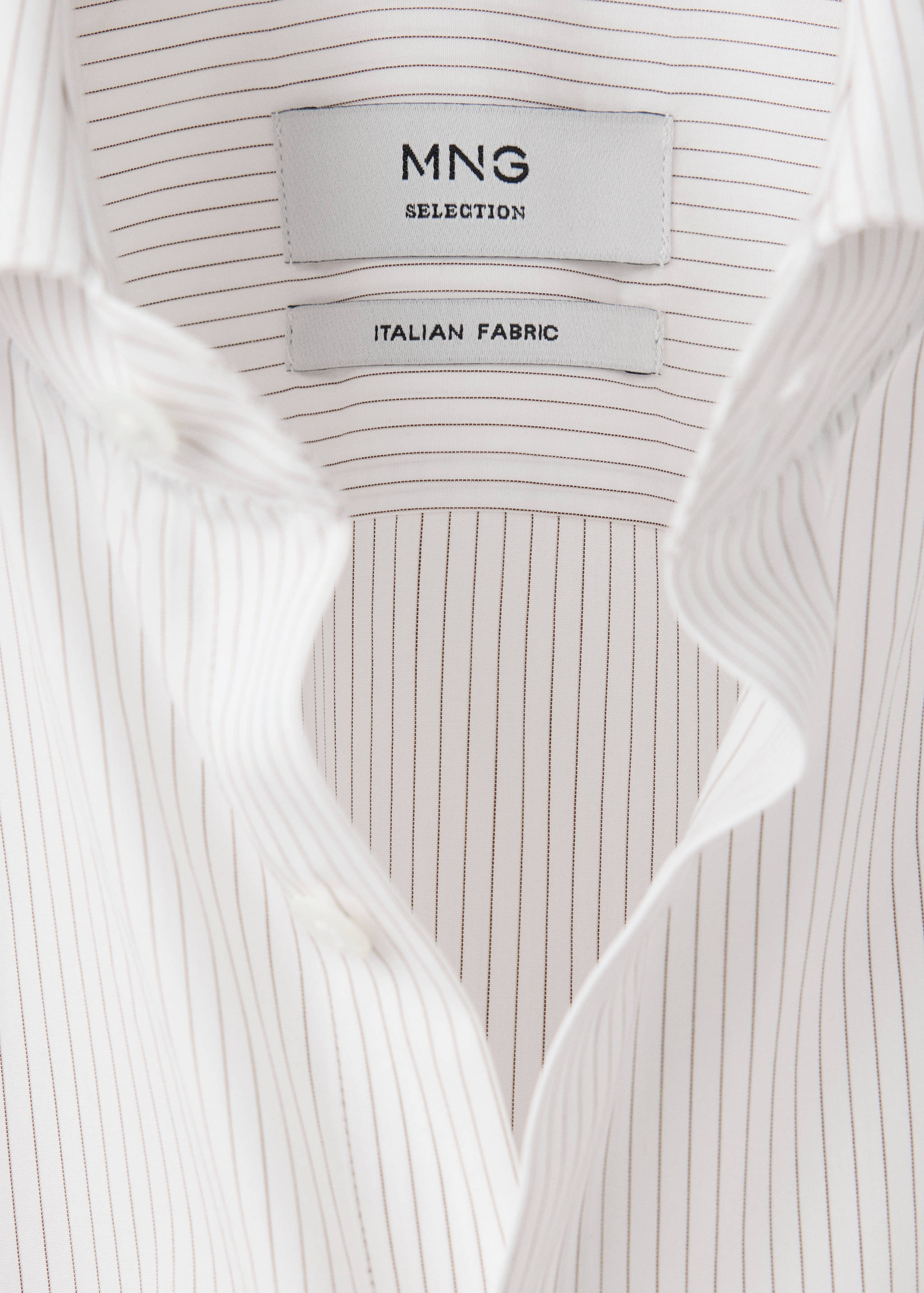 Close-up of a men's white pinstripe shirt collar and branded label.