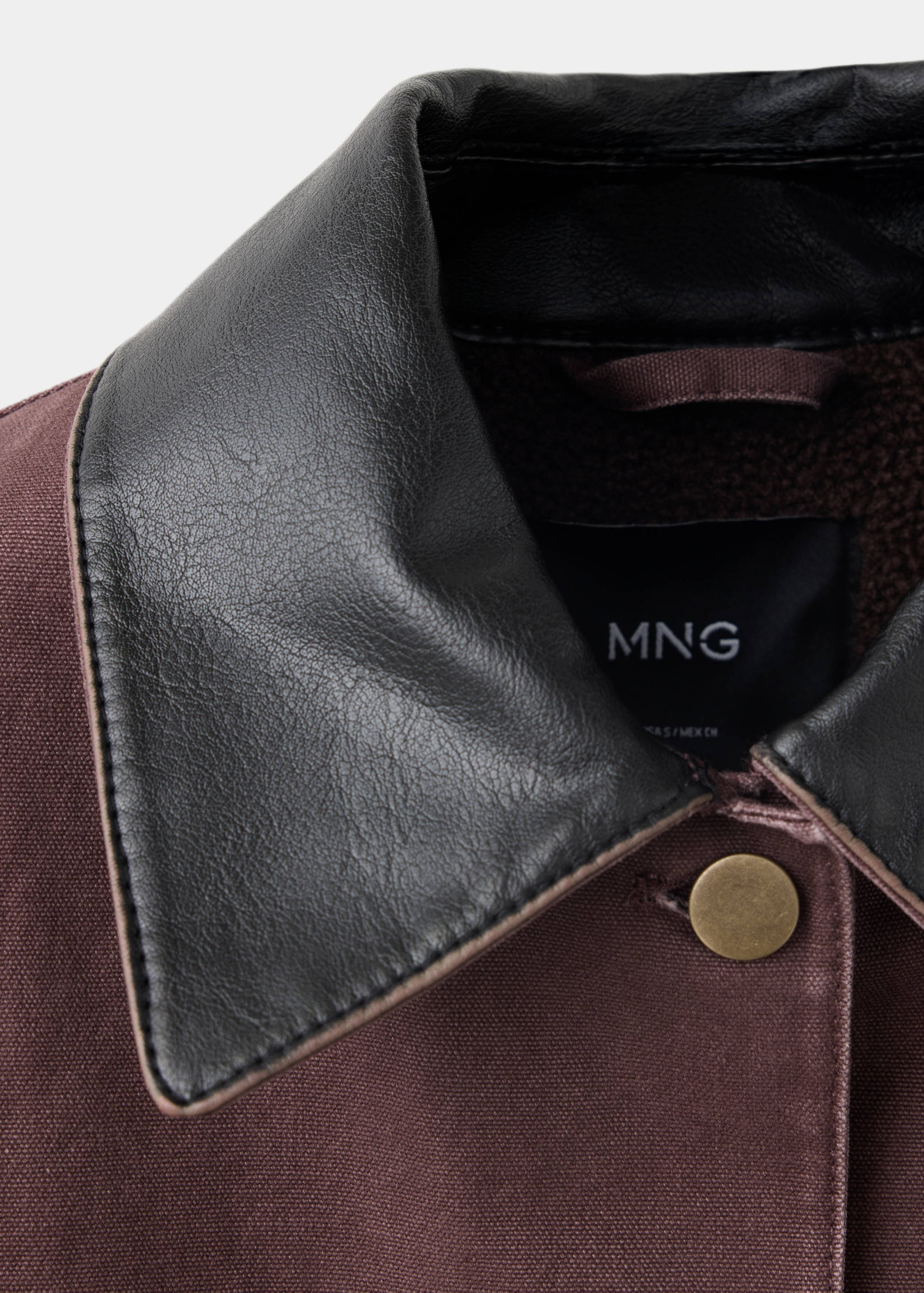 Burgundy parka collar detail featuring a black contrasting collar and metal snap button.