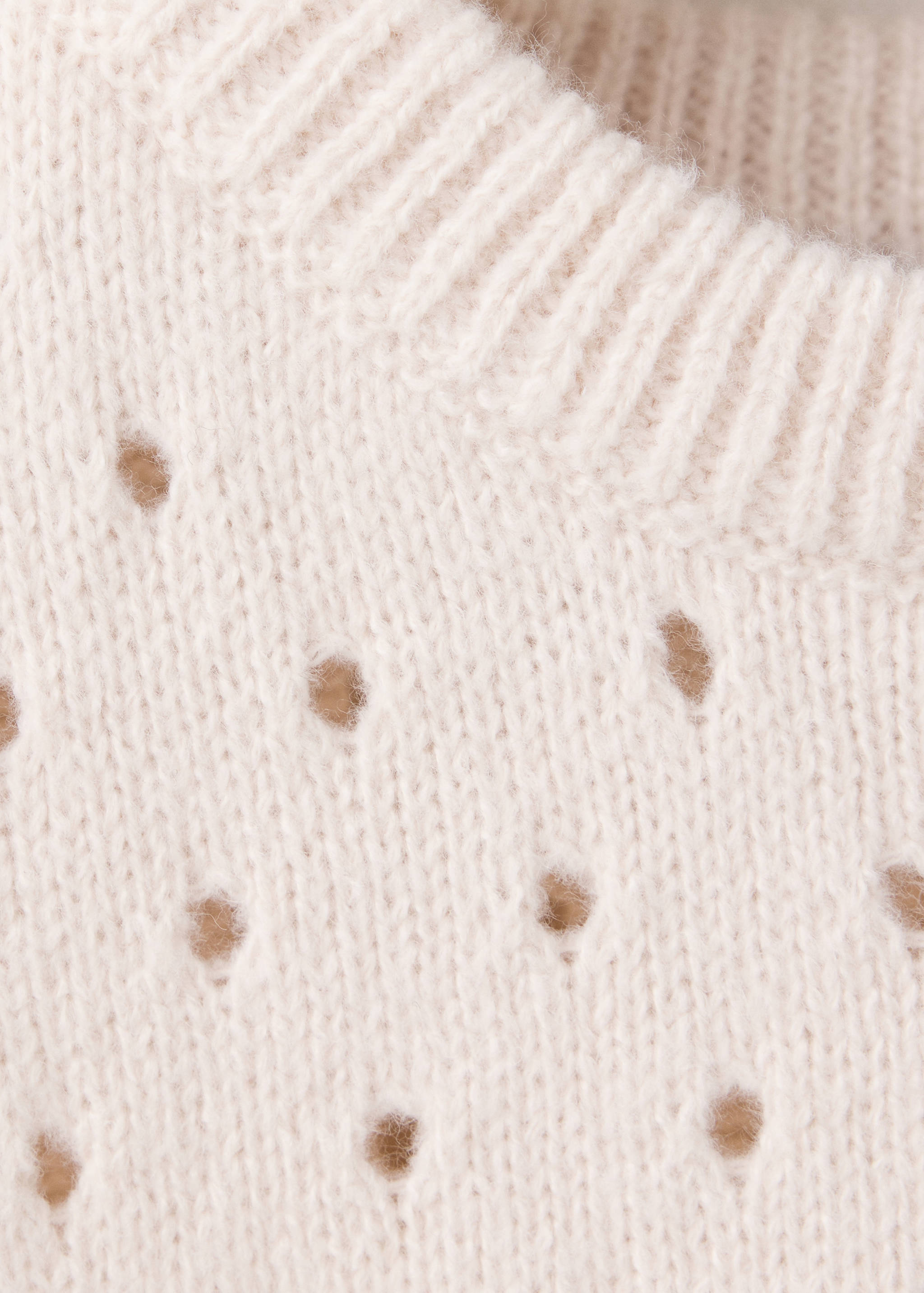 Cream knitted vest fabric detail with ribbed neckline