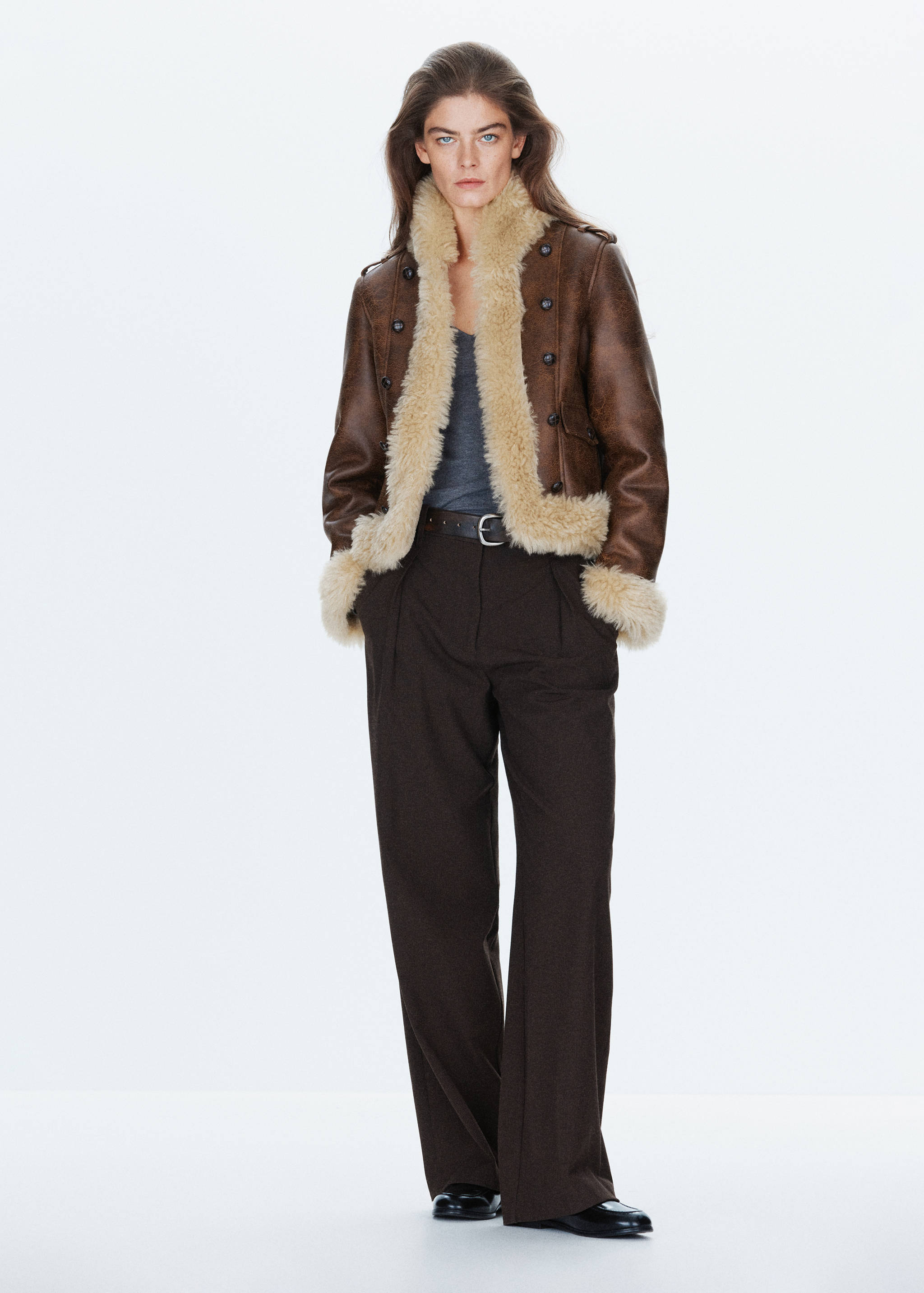 Brown jacket with cream faux-shearling lining, worn with dark trousers.