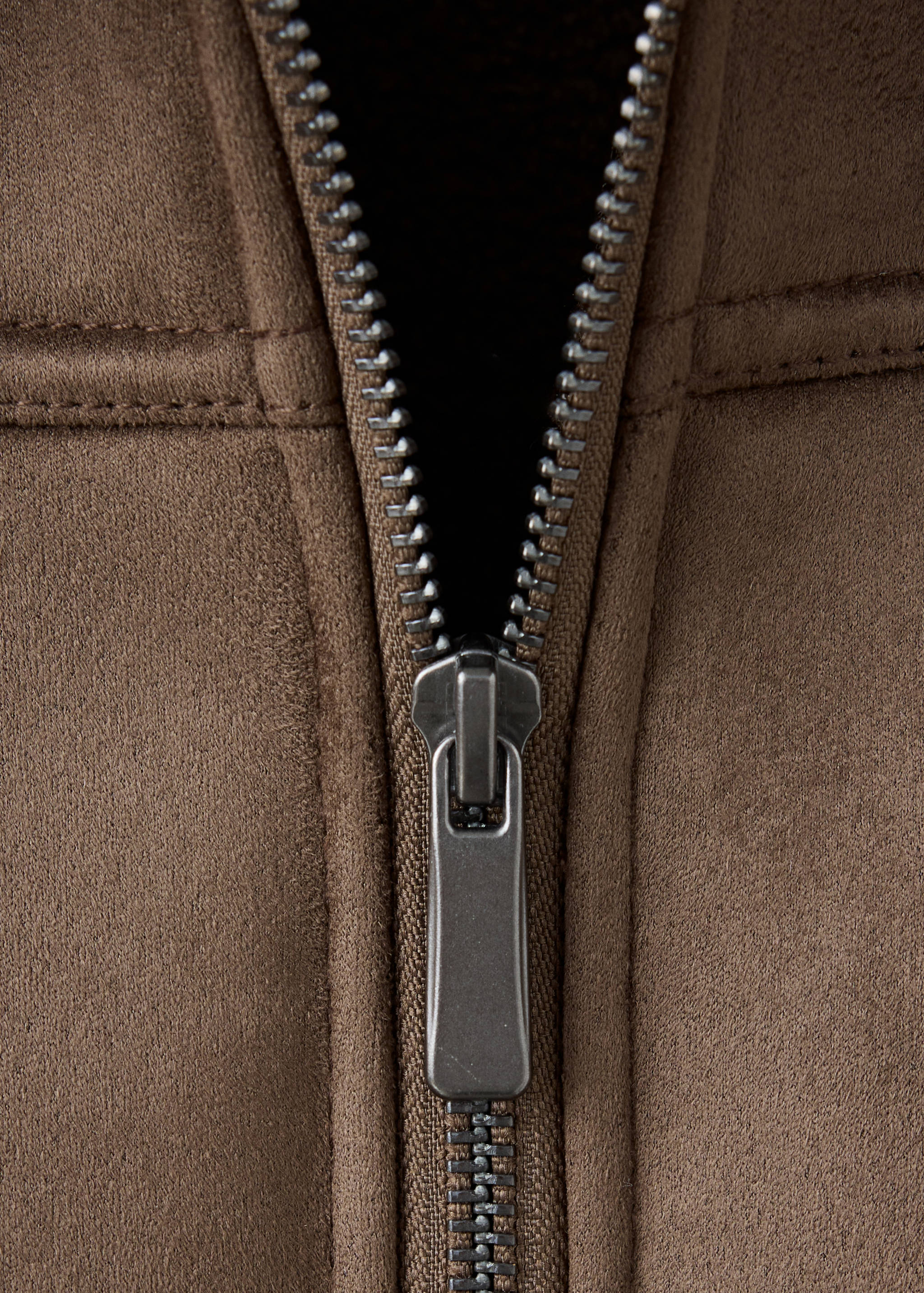 Close-up of a brown coat zipper.