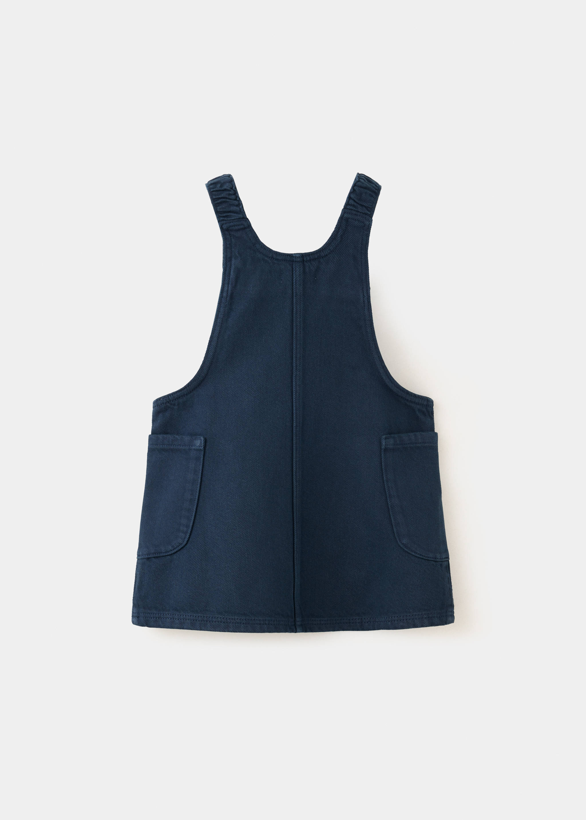 Dark blue kids' pinafore dress shown from the back with patch pockets.