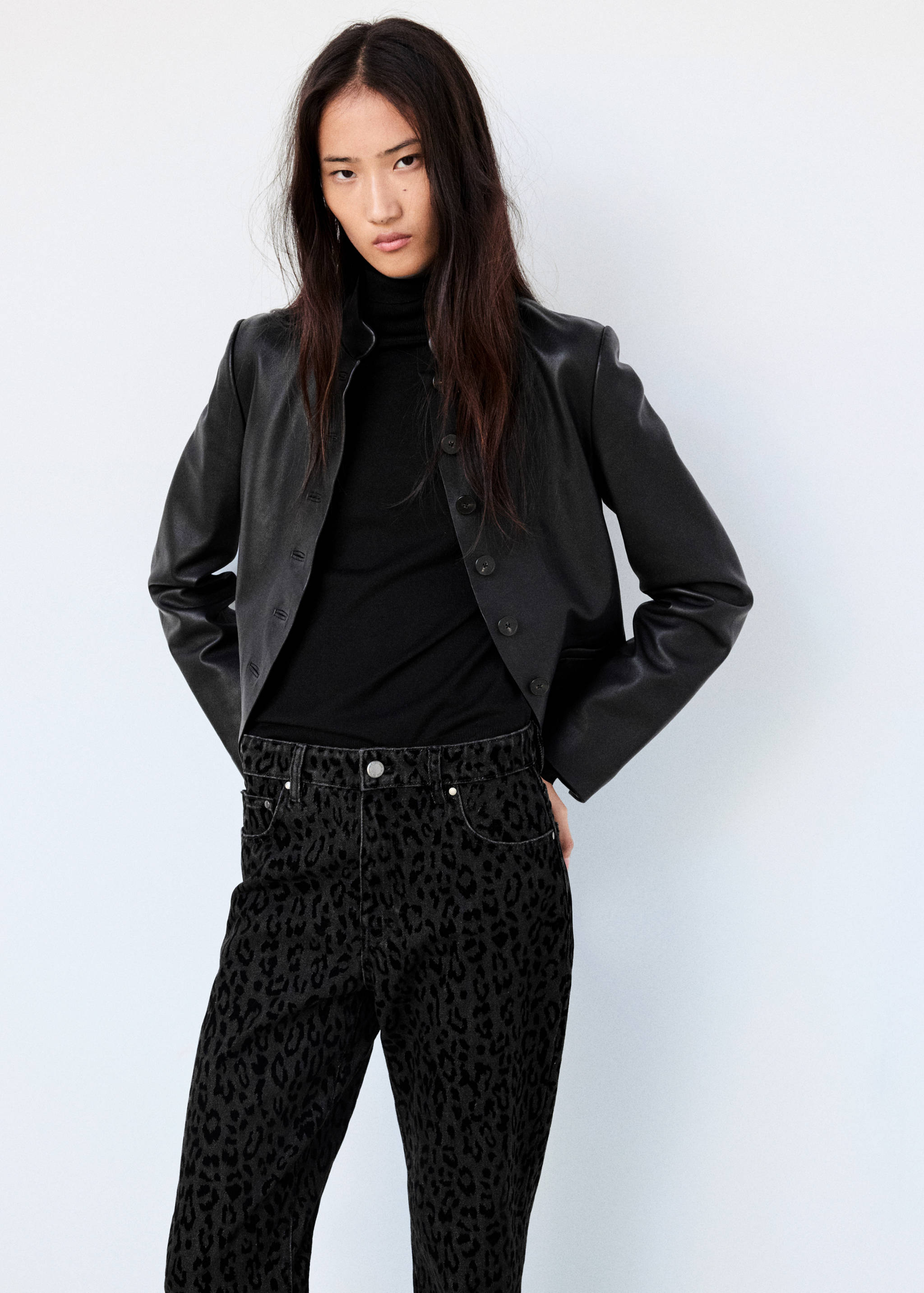 Dark leopard-print denim trousers worn with a black leather jacket.