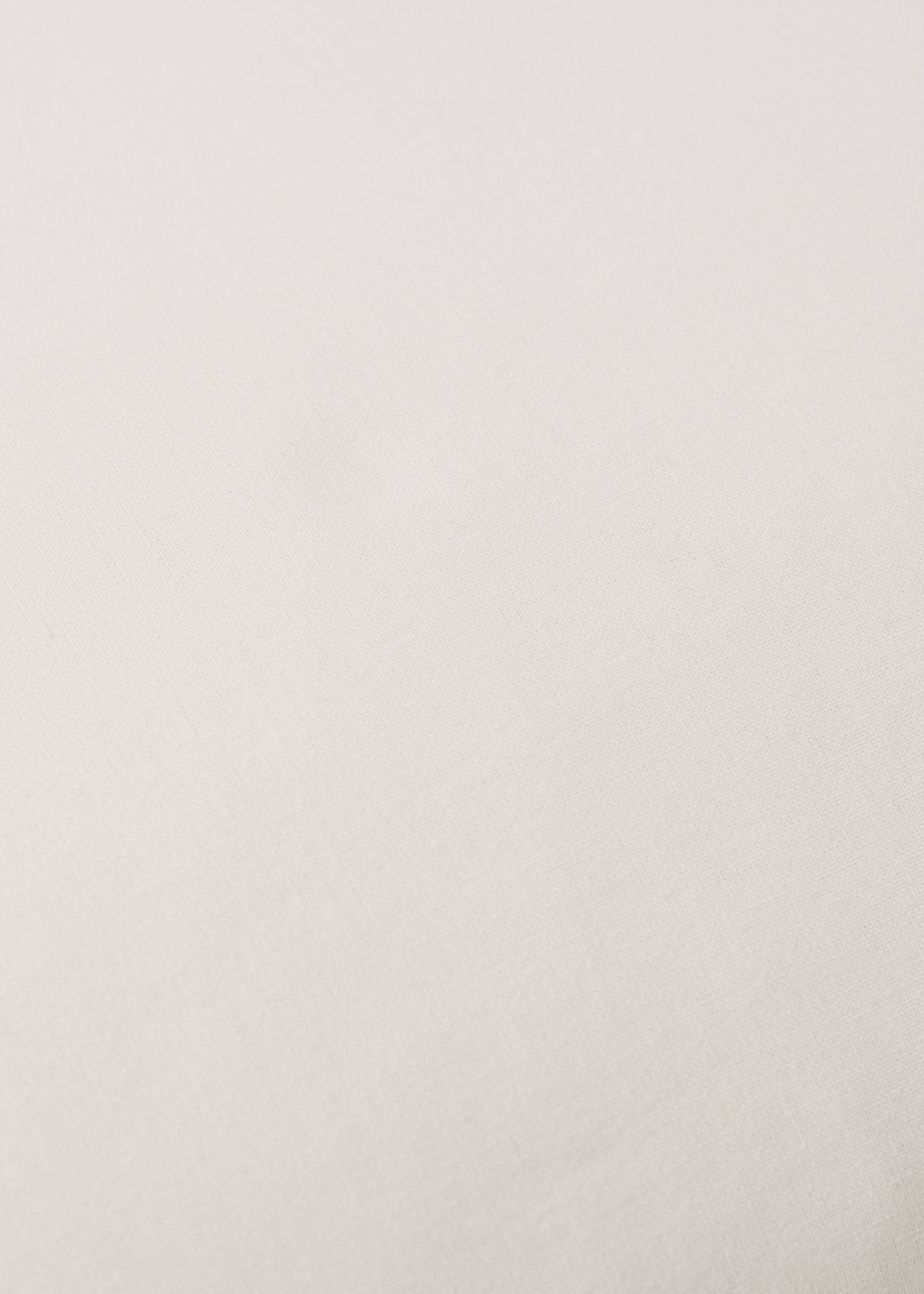 Cot pillowcase fabric detail in a light neutral tone.