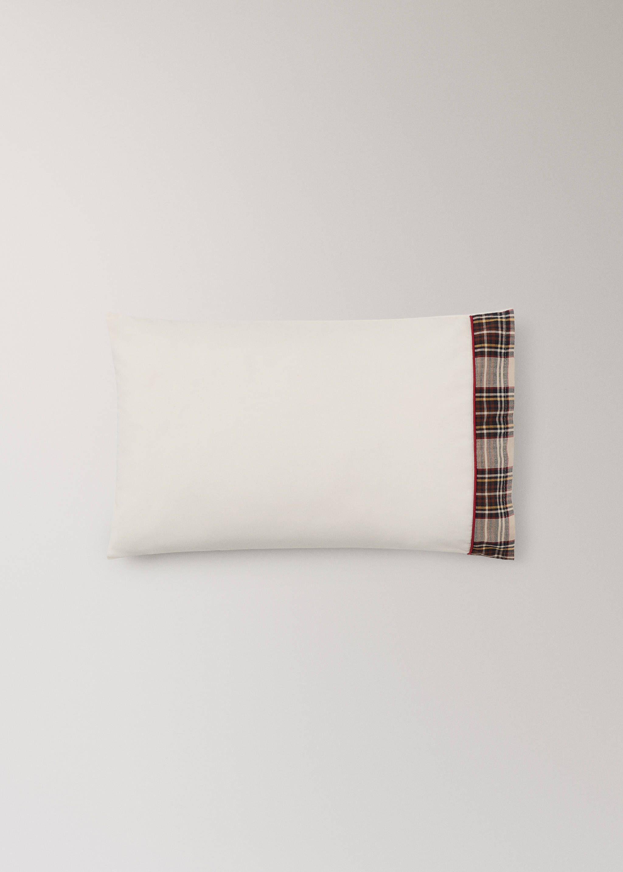 Off-white cot pillowcase with a tartan check border and red piping.