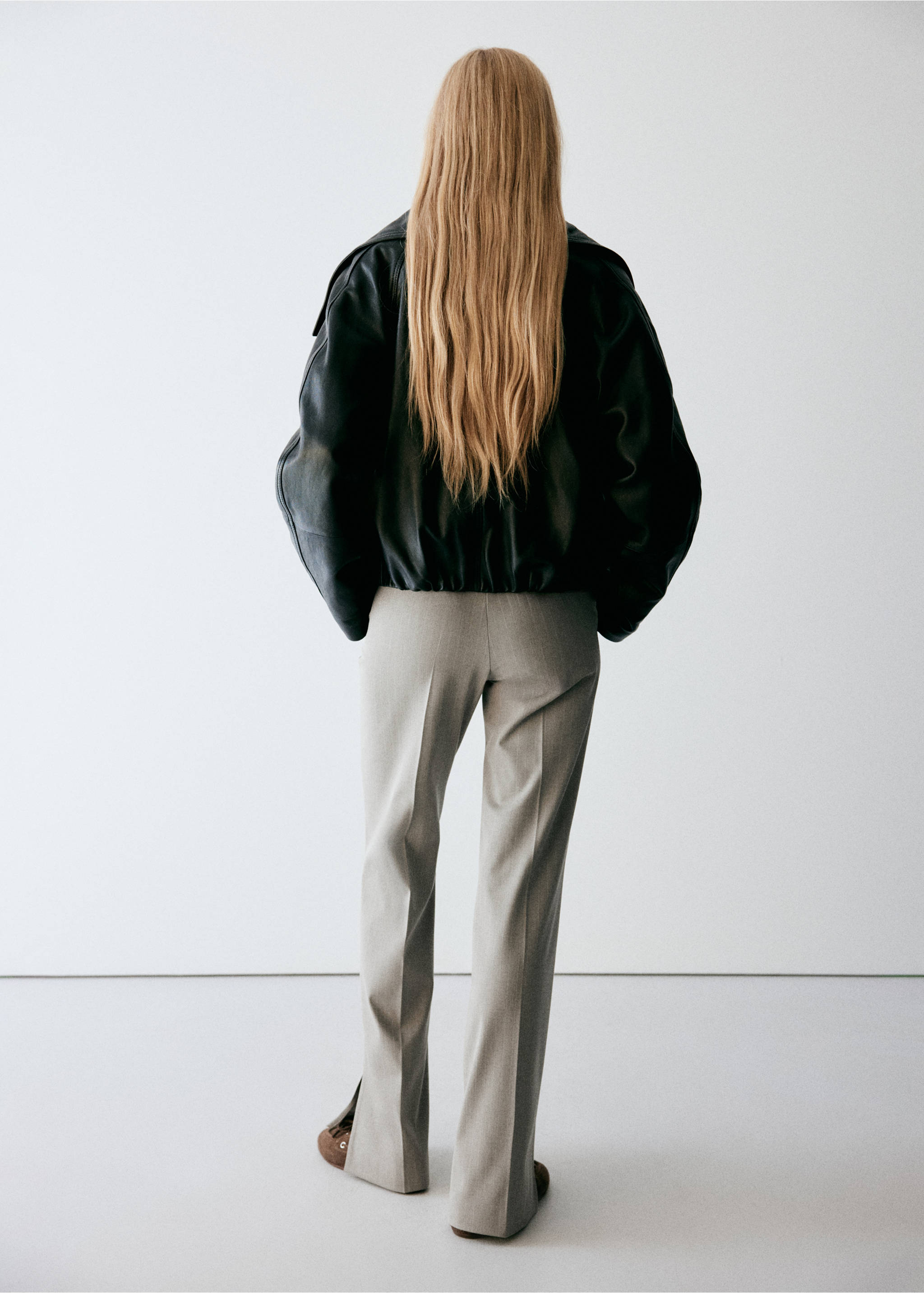 Grey trousers with pressed creases and hem slits, seen from the back., Medium Brown. Ref: 37068639-00.