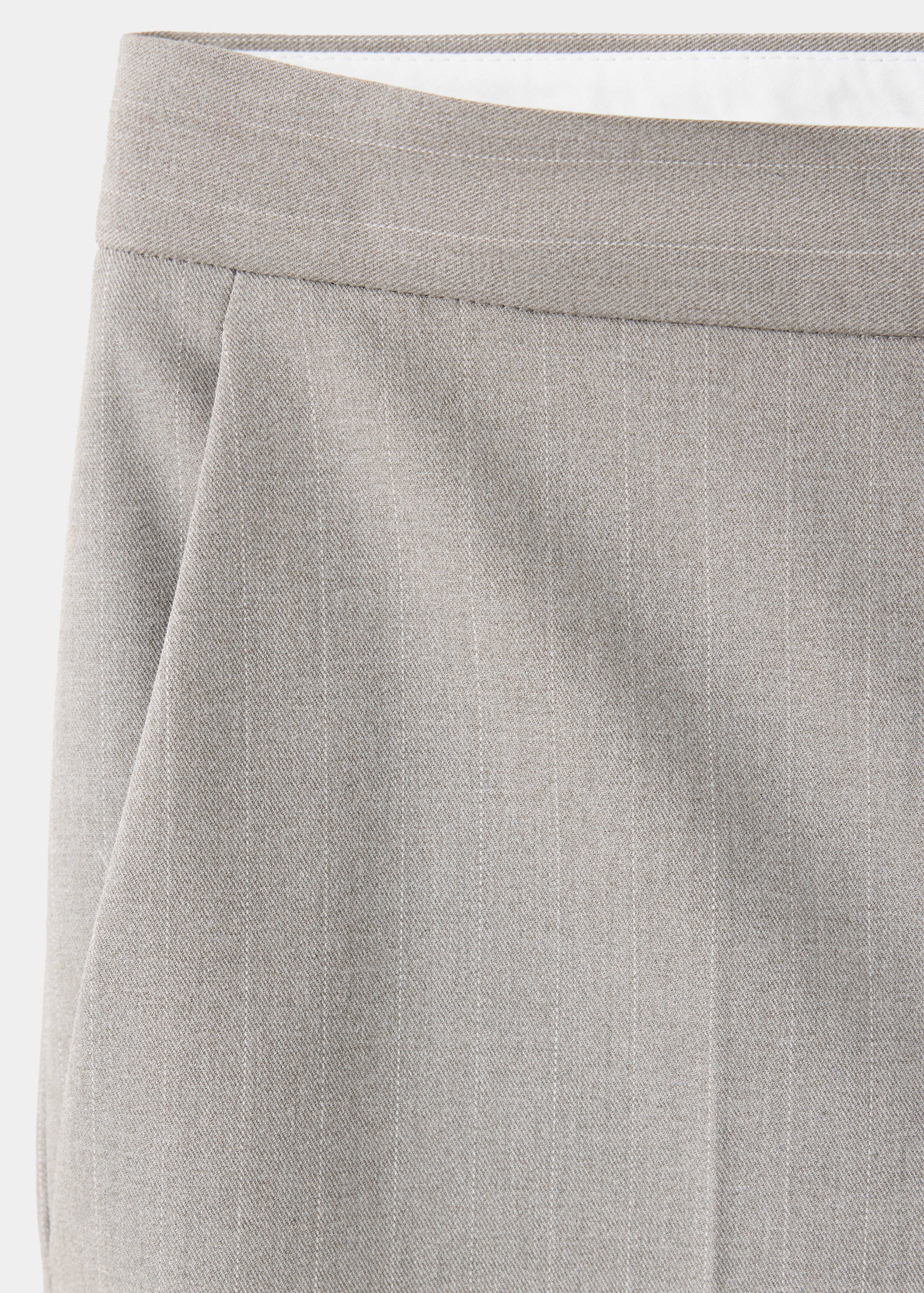 Detalle de pantalones grises de raya diplomática centrado en la cintura.