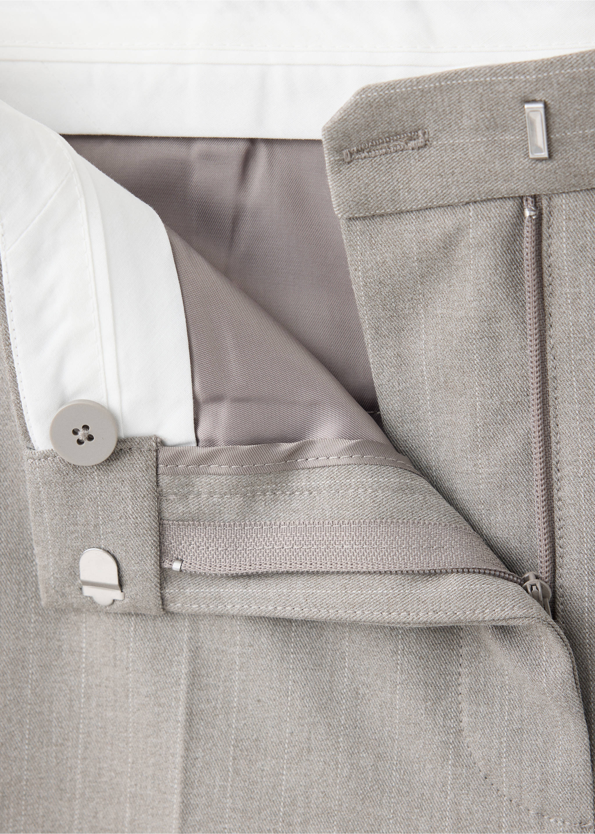 Detalle de la pretina y la bragueta con cremallera de unos pantalones de raya diplomática grises., Marrón medio. Ref: 37068639-00.