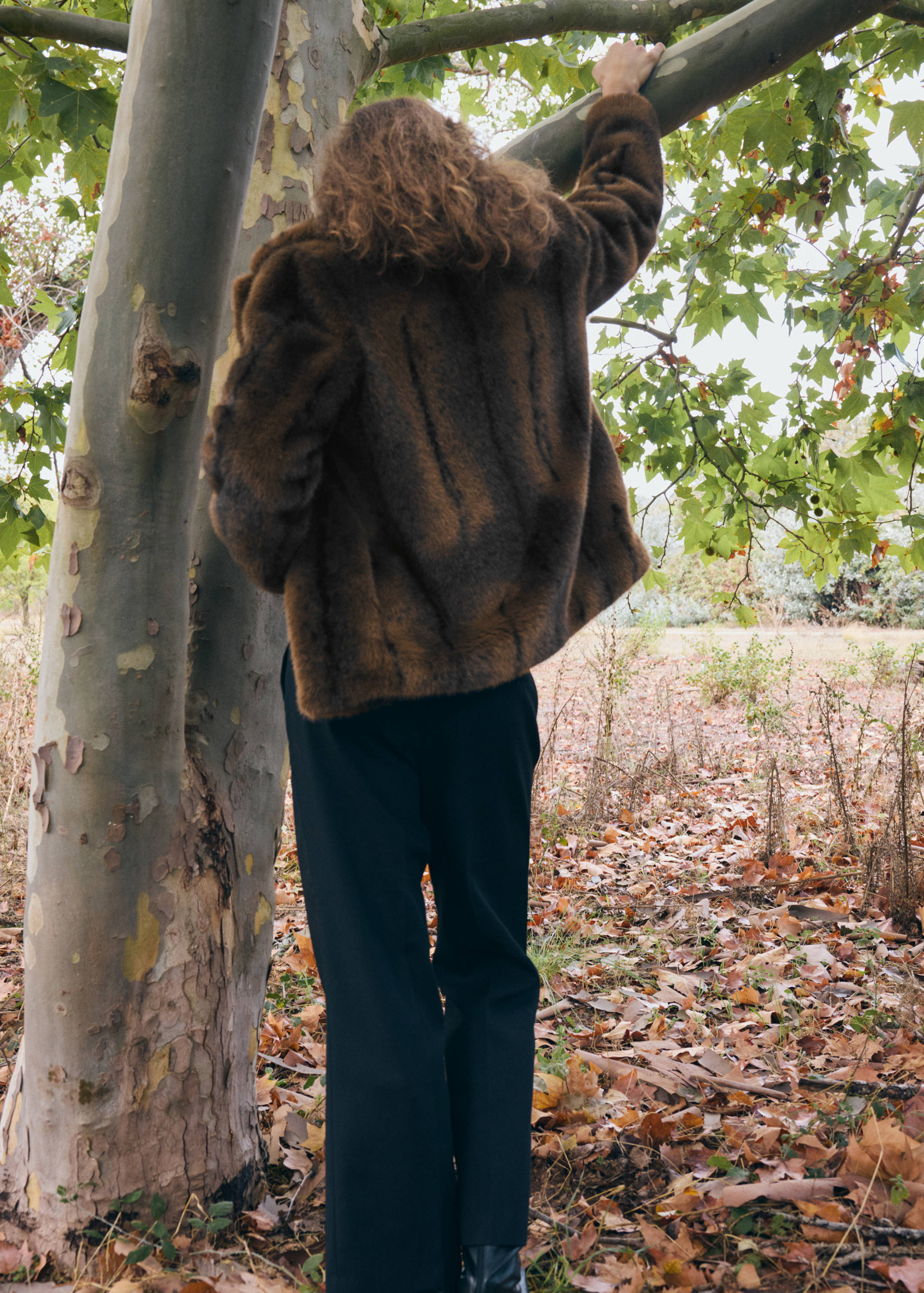 Brown faux-fur coat seen from the back in an outdoor setting