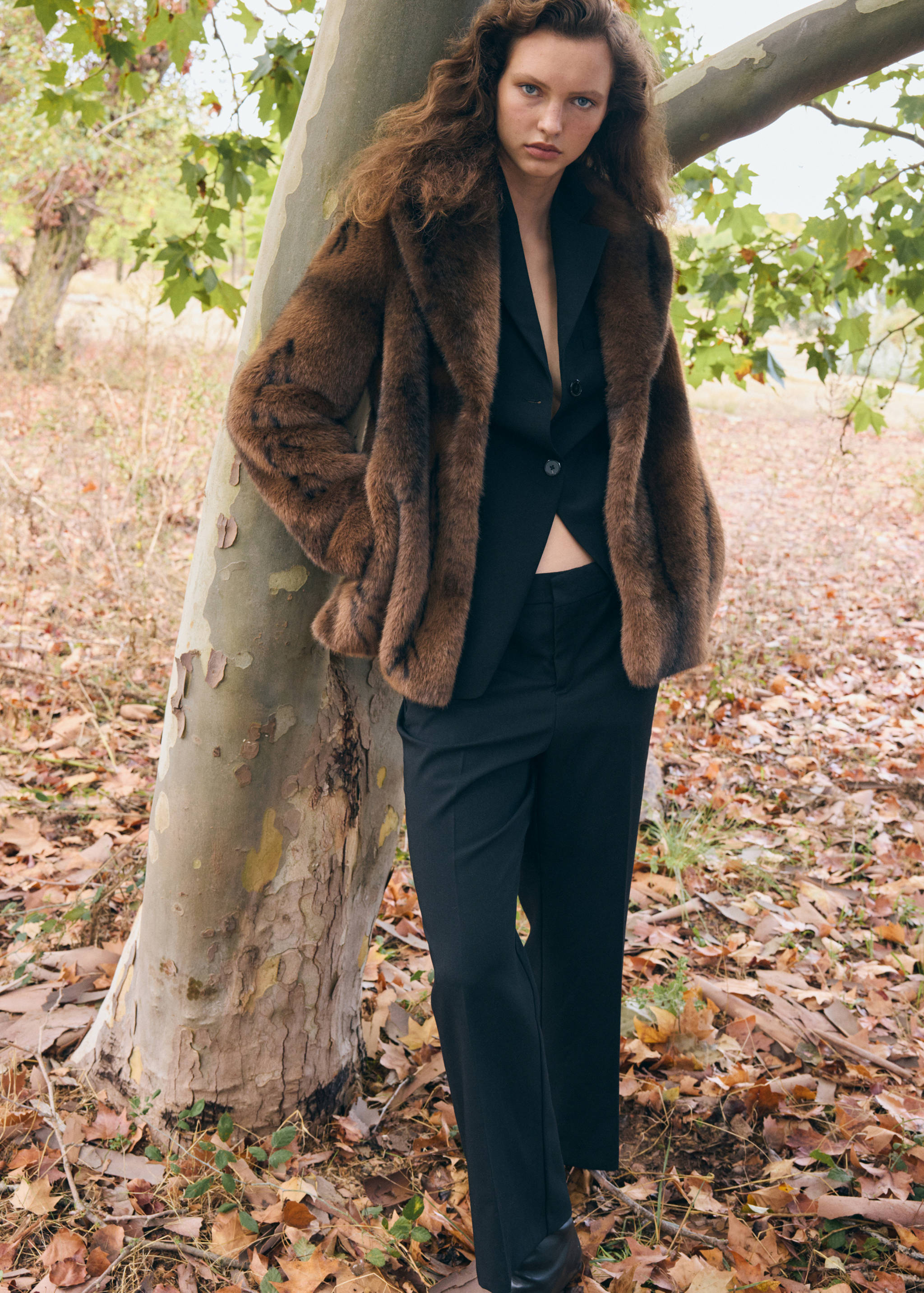 Brown faux-fur coat with wide lapels worn outdoors.