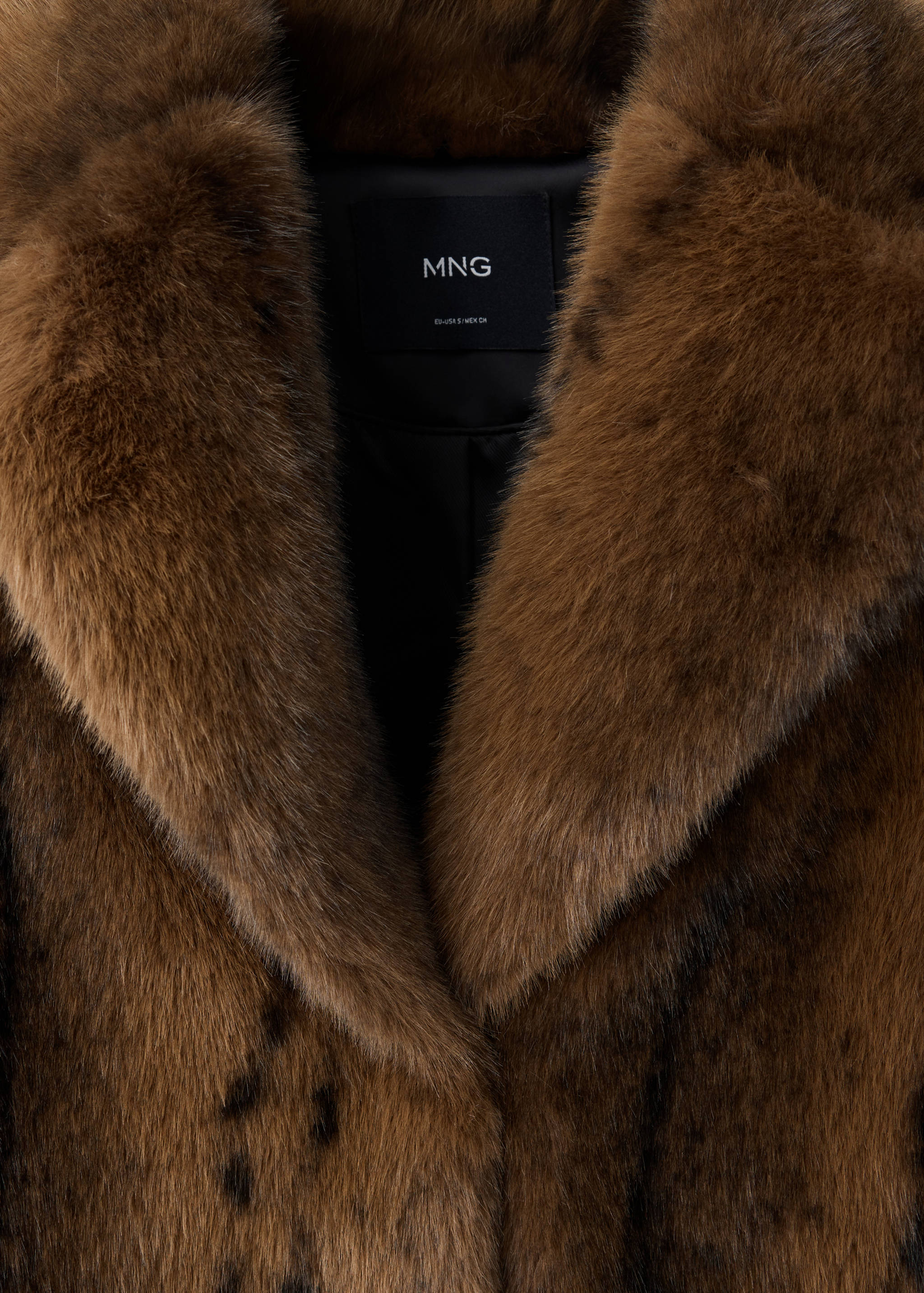 Close-up of a brown faux-fur coat collar with lapels and MNG brand label.