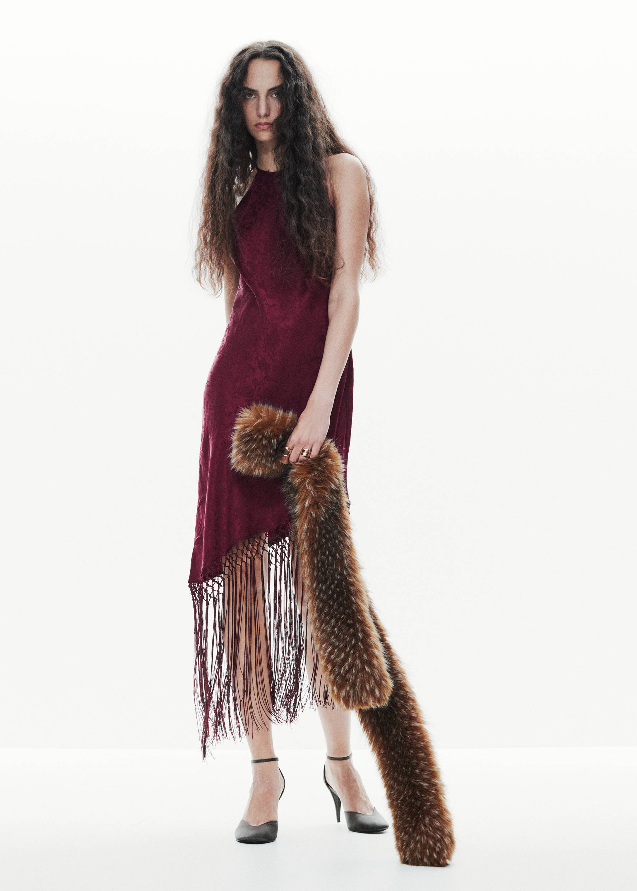 Burgundy sleeveless halter dress with an asymmetric fringe hem.