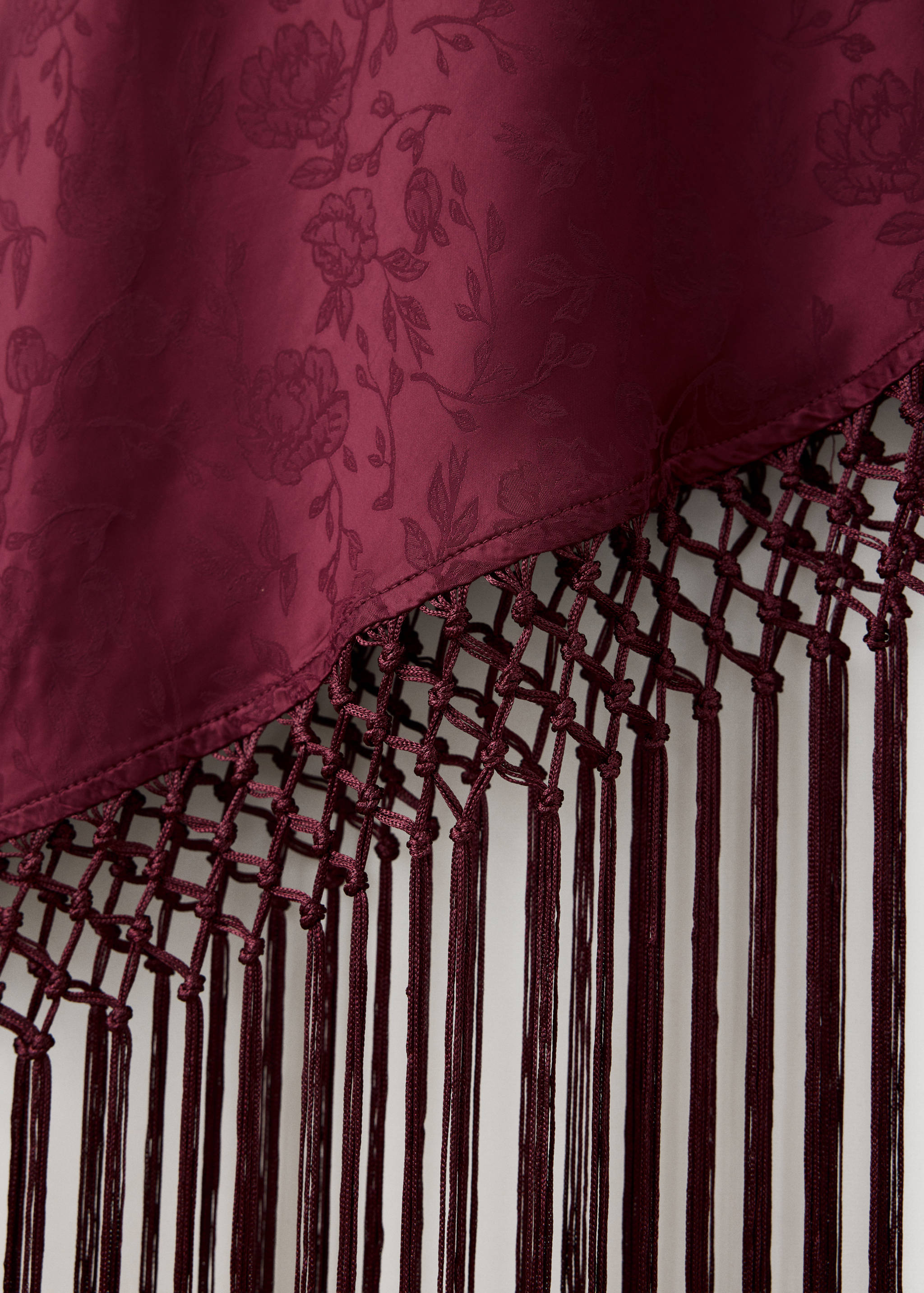 Burgundy jacquard dress fabric and macramé fringe hem detail.