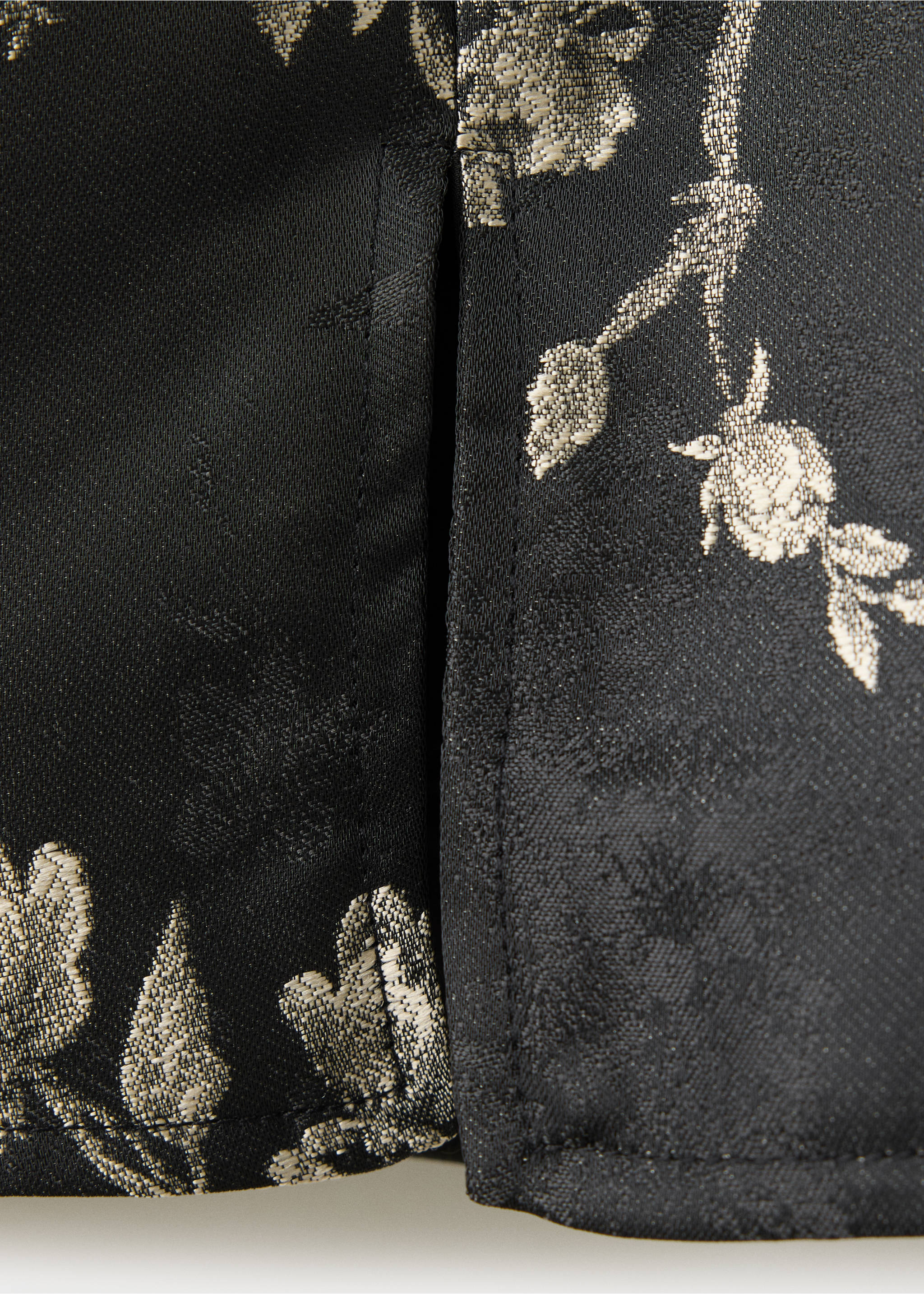 Close-up of black dress fabric with a metallic gold floral jacquard pattern., Black. Ref: 37069117-00.