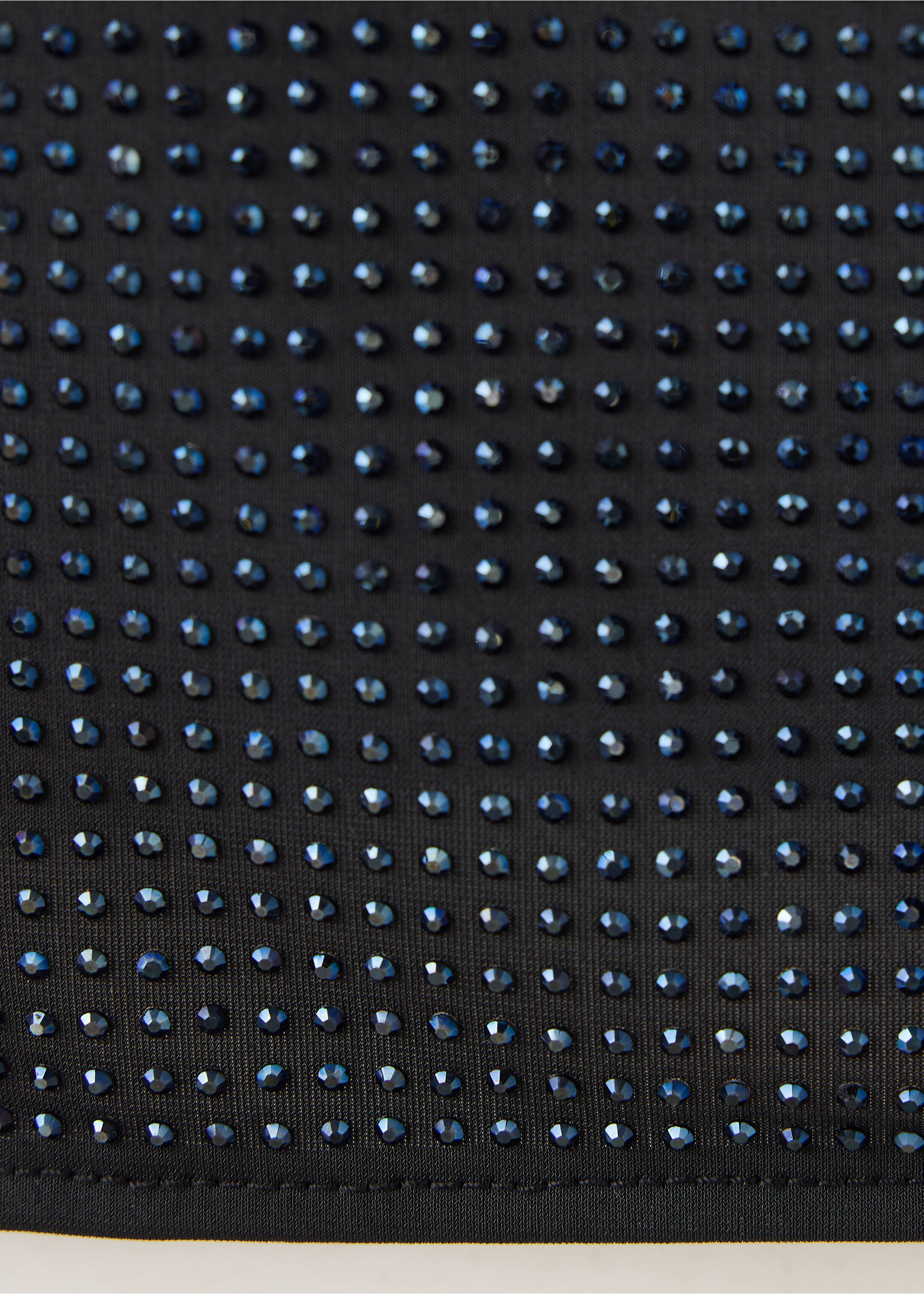 Close-up of a black top embellished with small dark rhinestones., Black. Ref: 37069119-00.
