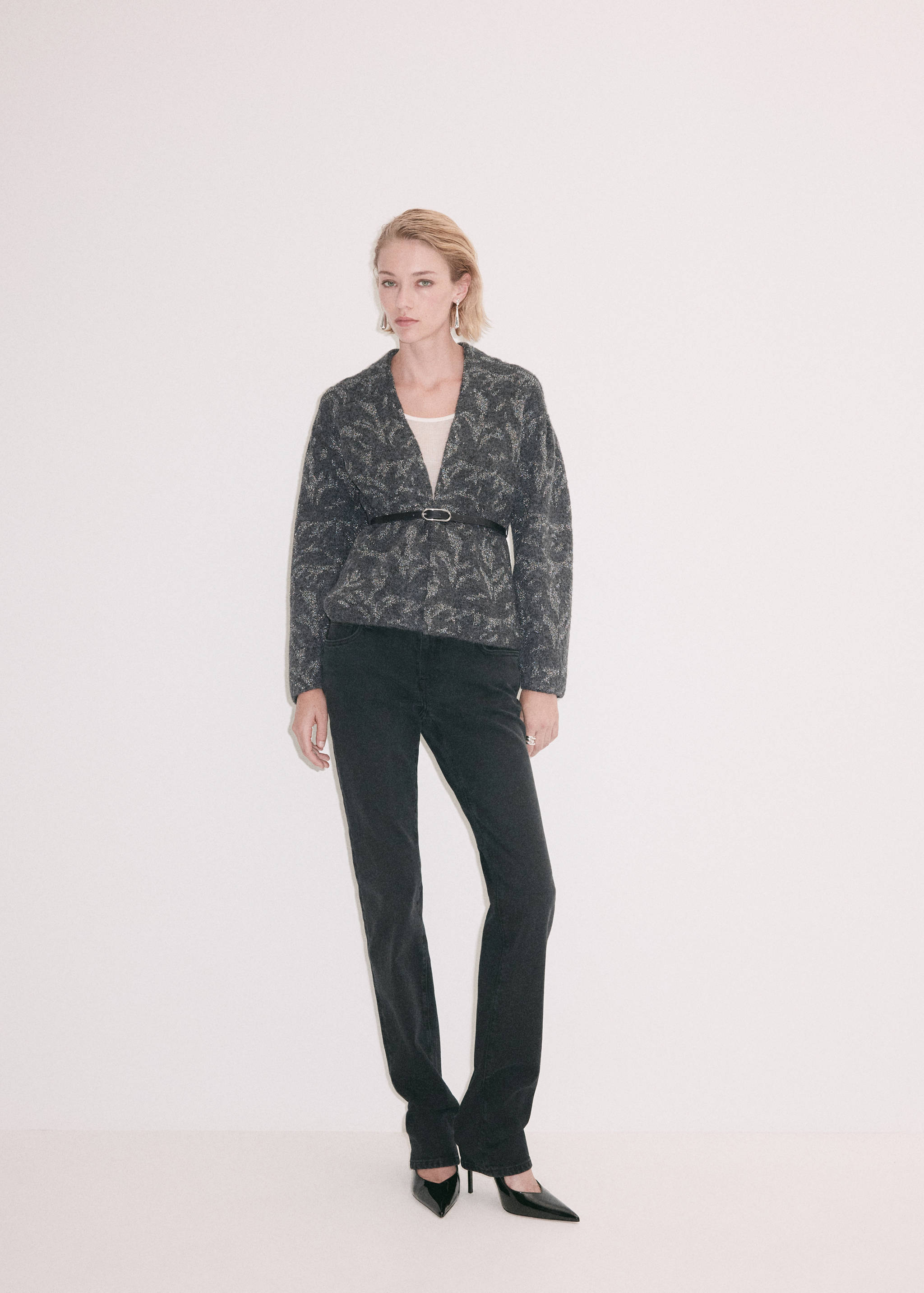 Dark grey patterned jacket with a V-neckline, worn belted.