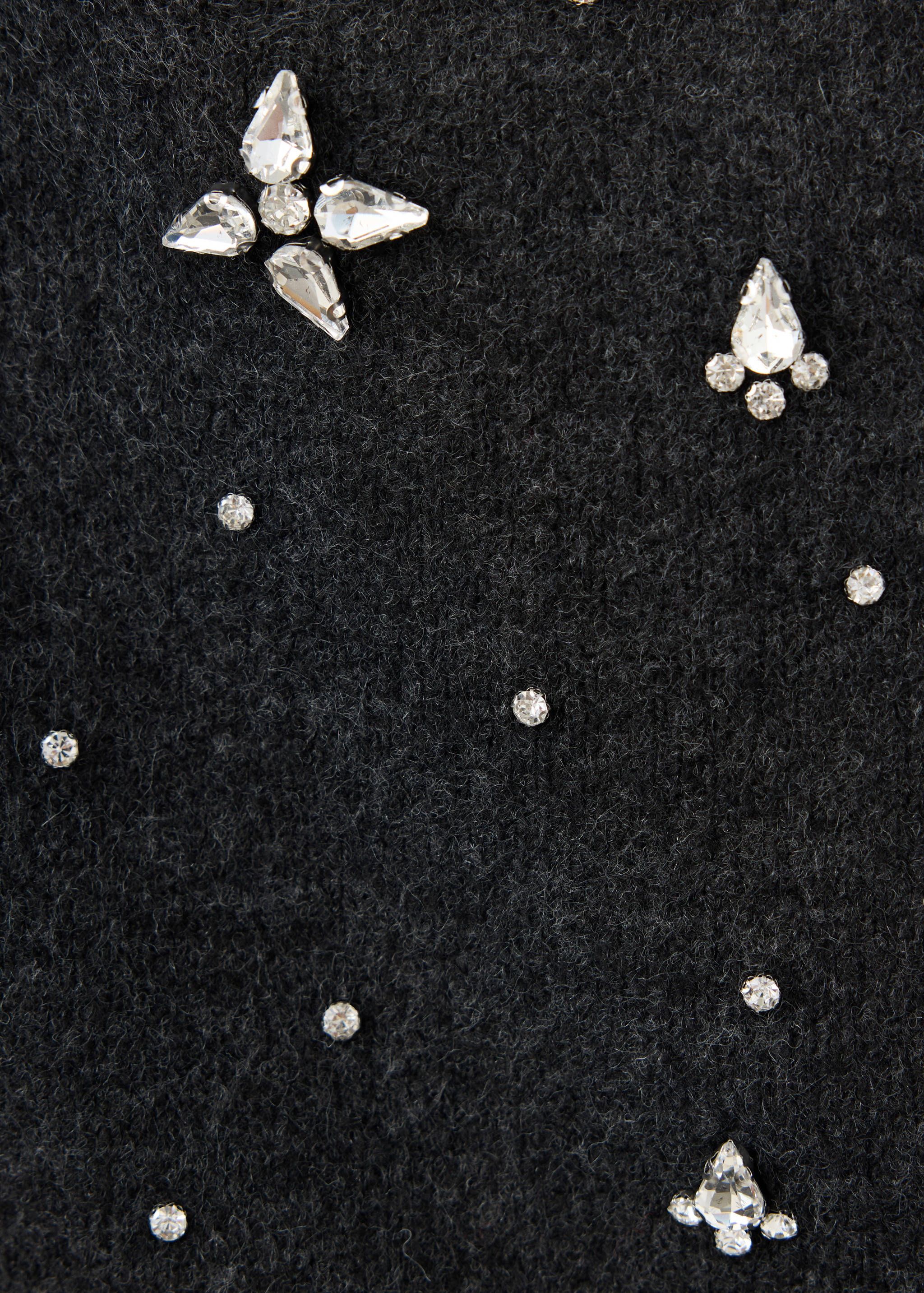 Close-up of a black textured top embellished with rhinestones.