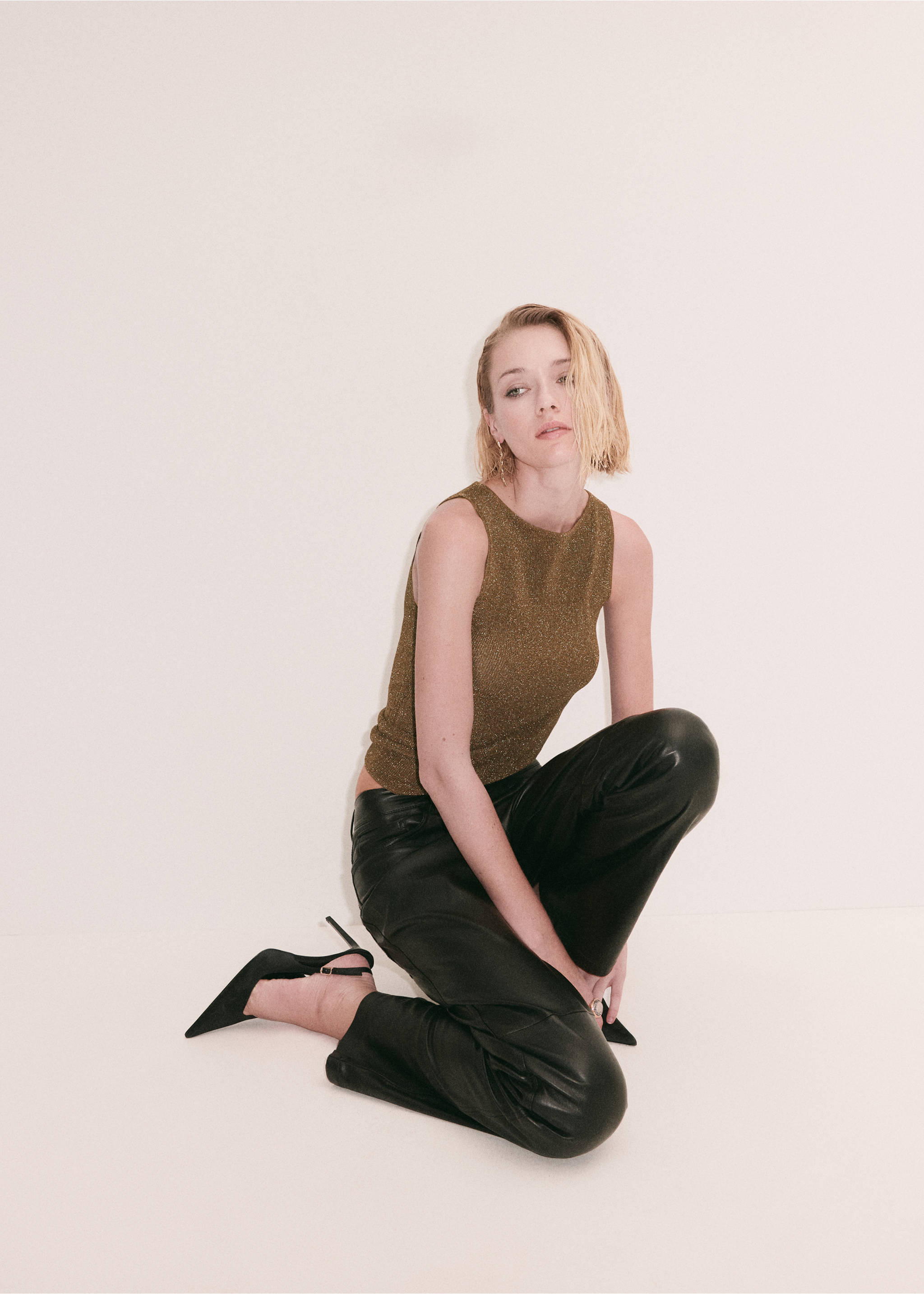 Metallic gold sleeveless fitted top with a rounded neckline, worn with black trousers., Gold. Ref: 37069126-00.