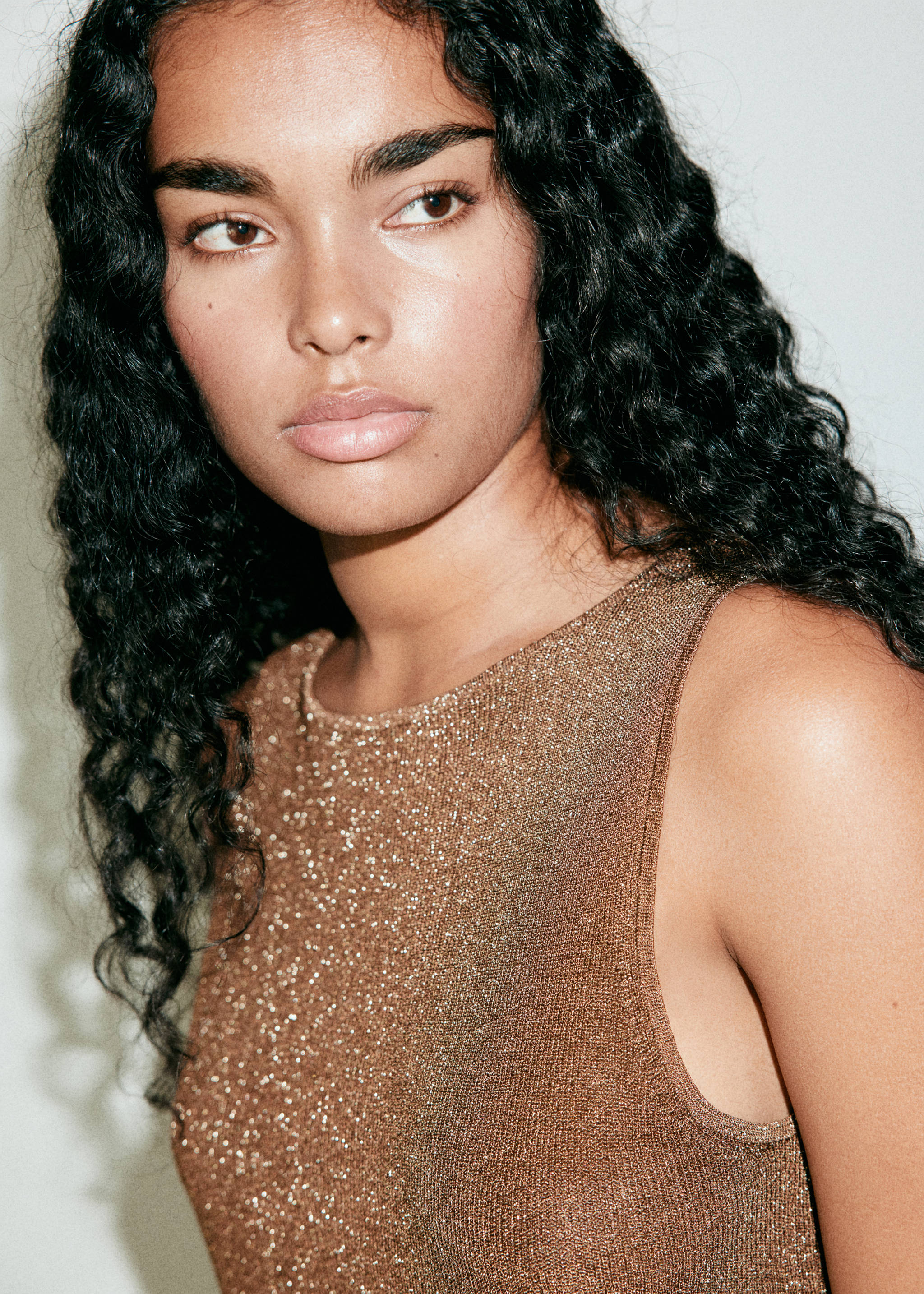 Metallic bronze sleeveless knit top with a round neckline.