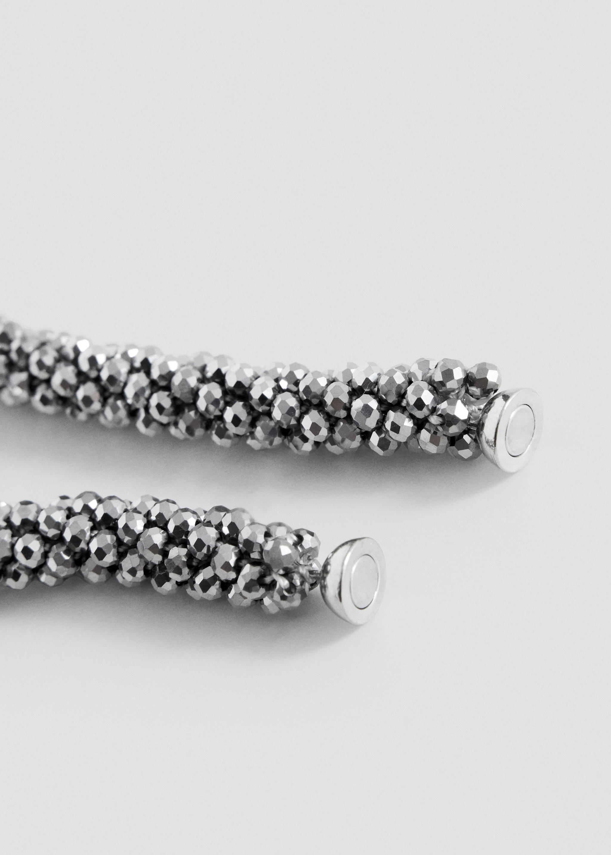 Close-up of a silver beaded collar necklace with magnetic clasps.