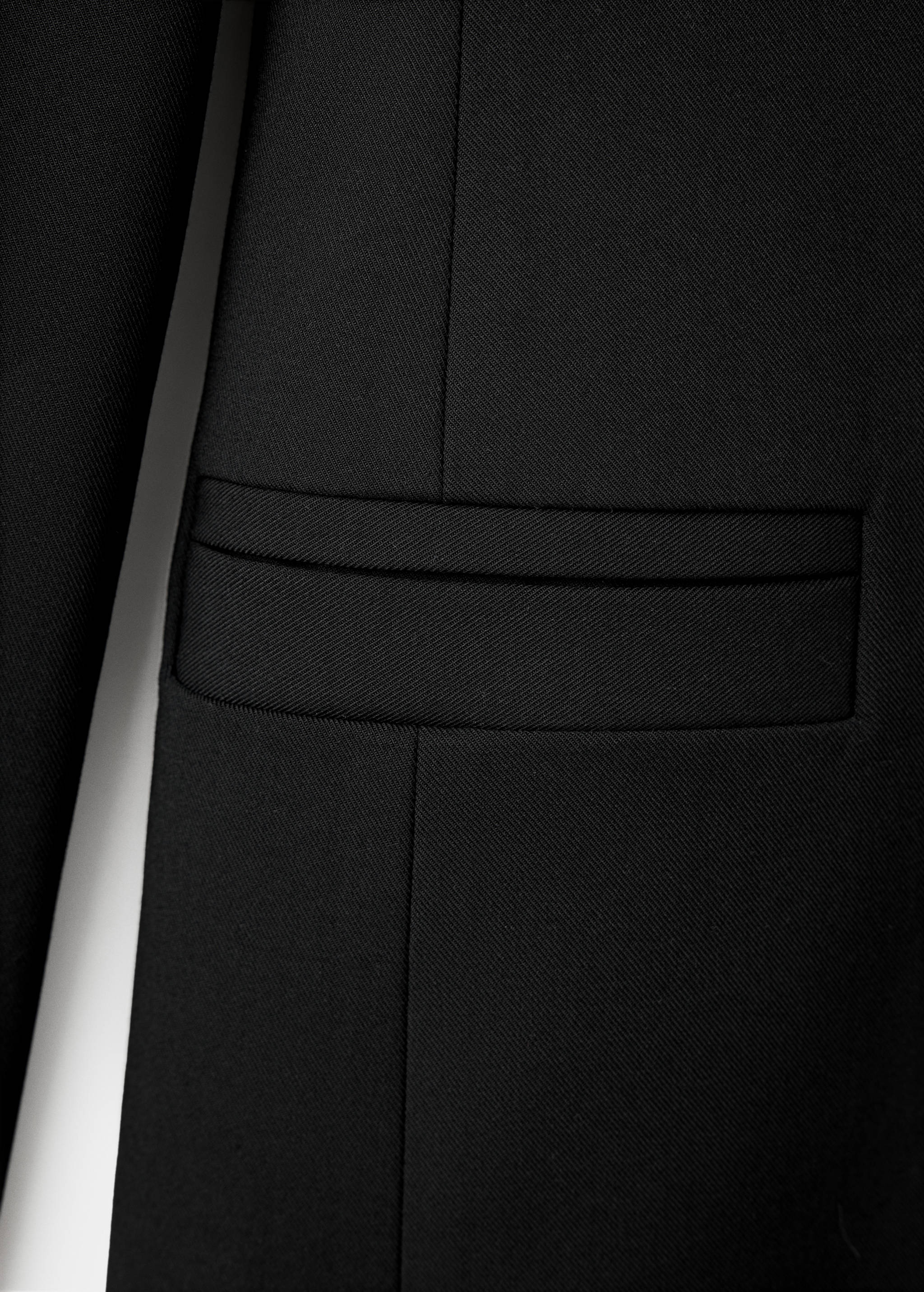 Close-up of black dress fabric showing pocket detail.