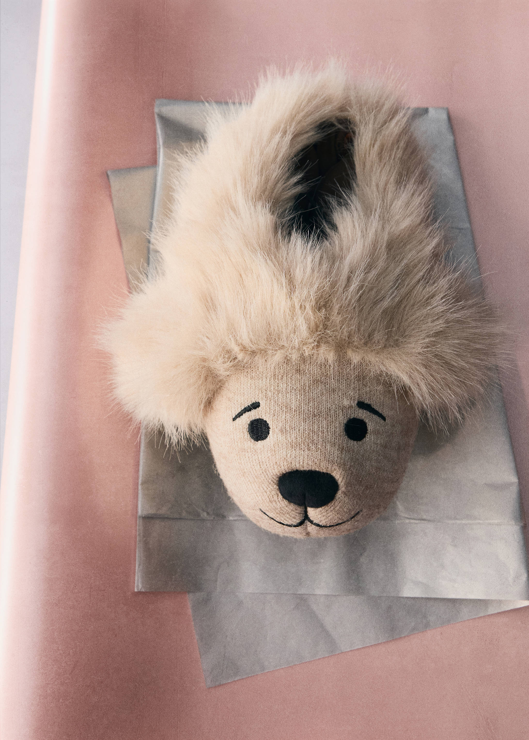 Beige knit children's slipper featuring an embroidered bear face and fluffy faux-fur trim.