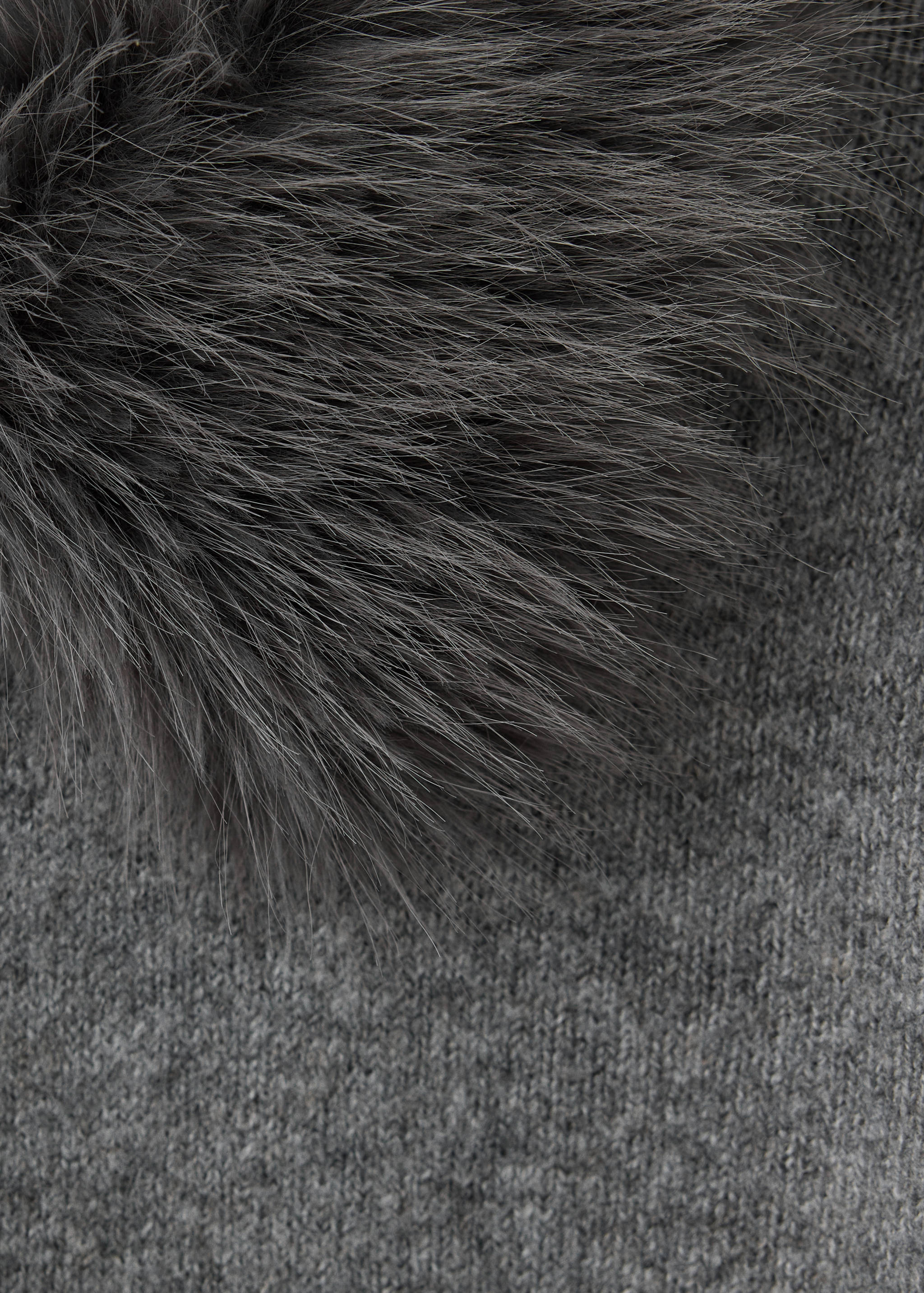 Close-up of a grey cardigan featuring faux-fur trim and a fine knit.
