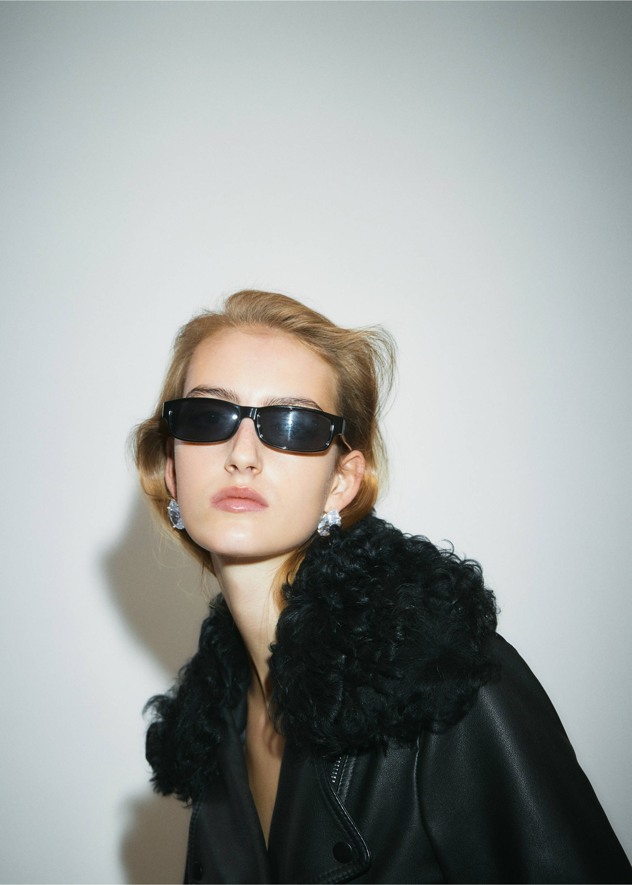 Black jacket with a textured faux-fur collar, shown in a close-up portrait., Black. Ref: 37069141-00.