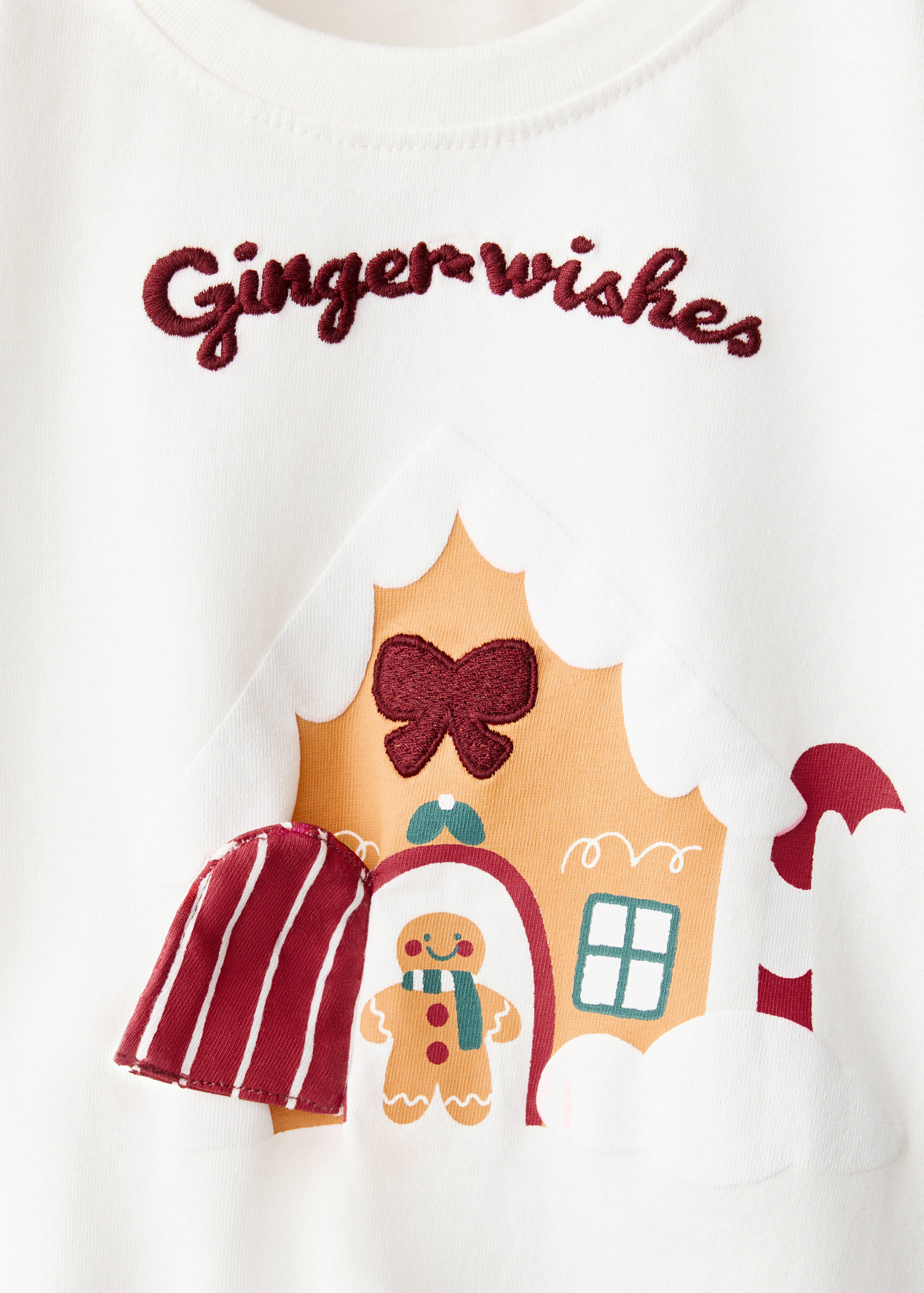Off-white t-shirt with a gingerbread house graphic and embroidered text.