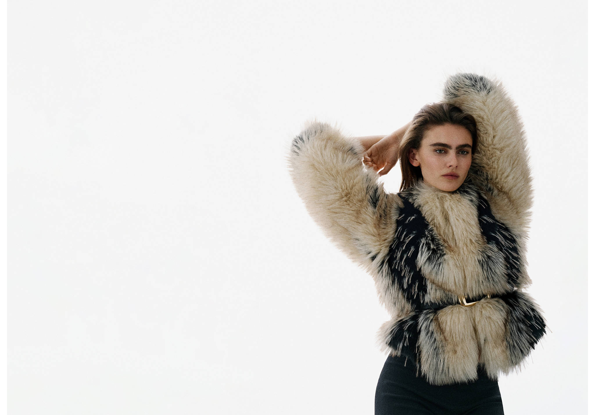Black belt with a gold-toned buckle worn with a patterned faux-fur jacket