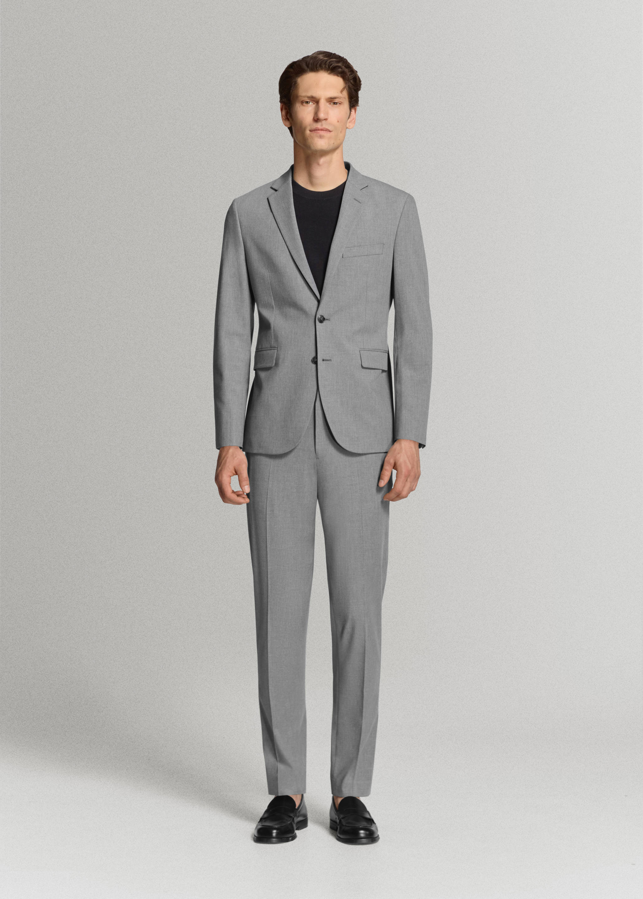 Grey slim-fit trousers with pressed creases, worn with a matching blazer.