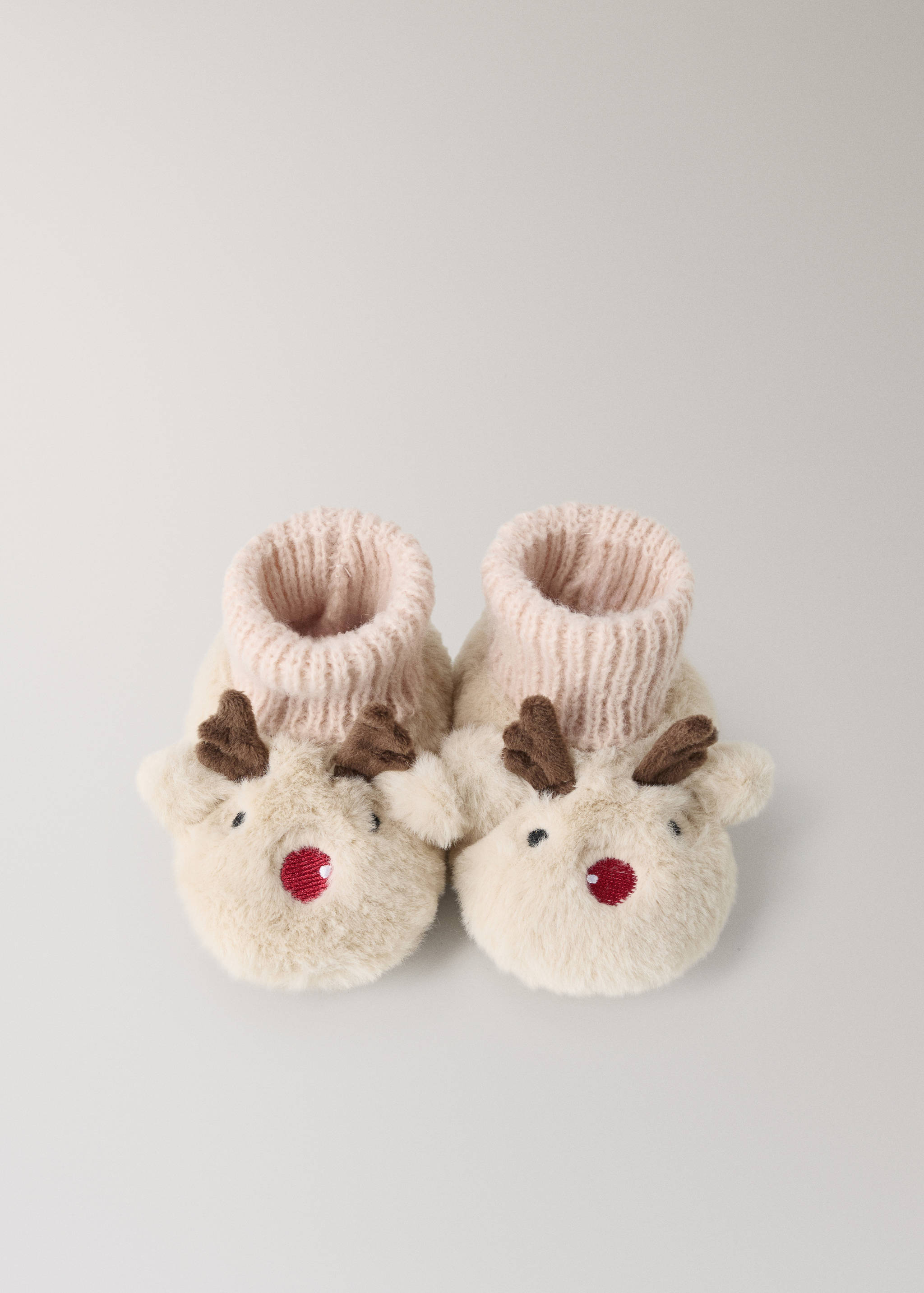 Cream faux-fur house slippers with ribbed cuffs and reindeer face details.