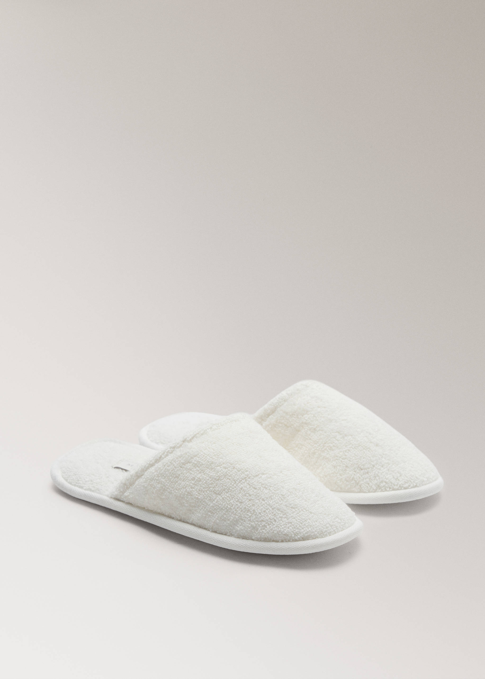 White textured towelling bathroom slippers with closed toes.