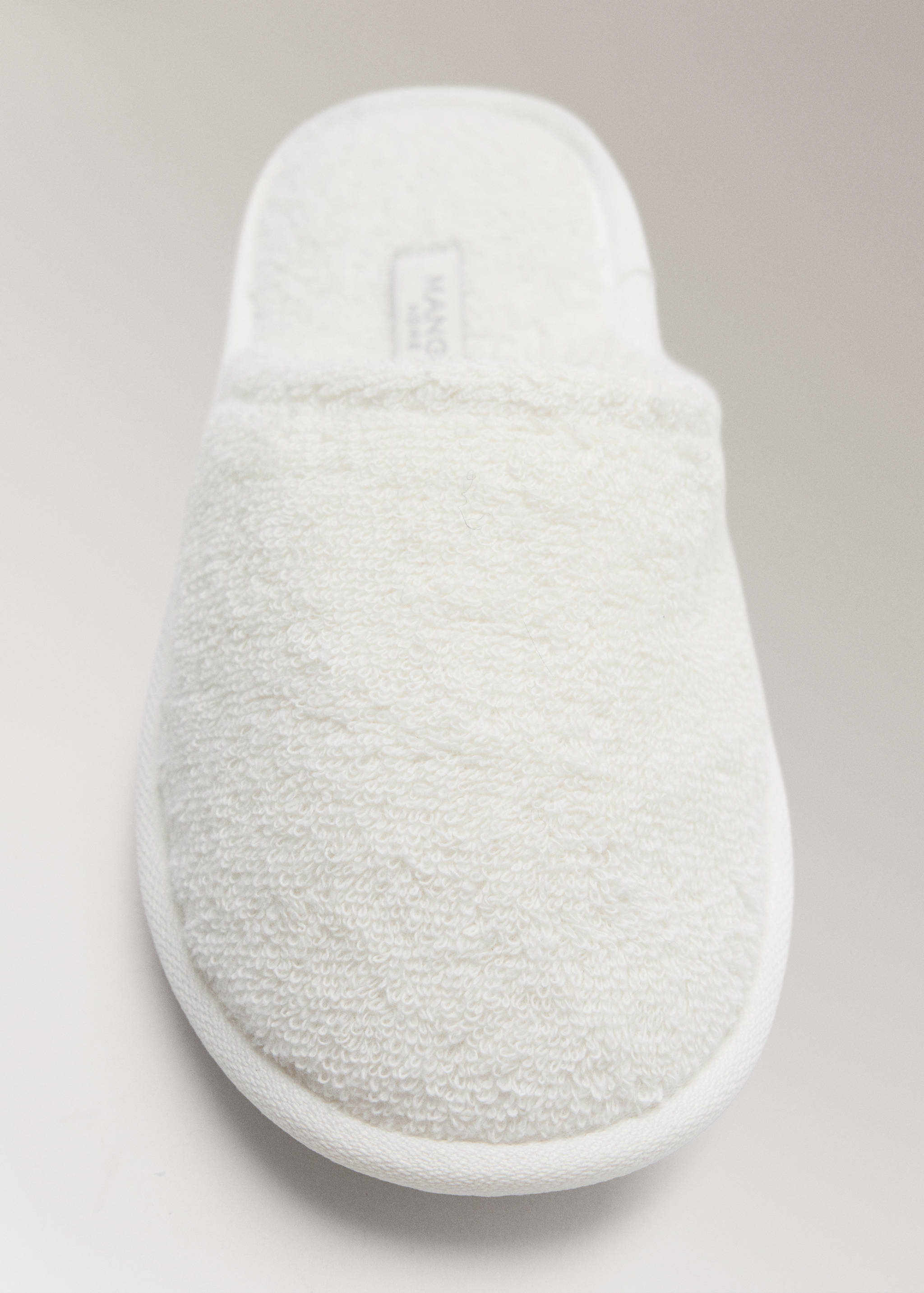 White towelling bathroom slipper in a close-up product view.