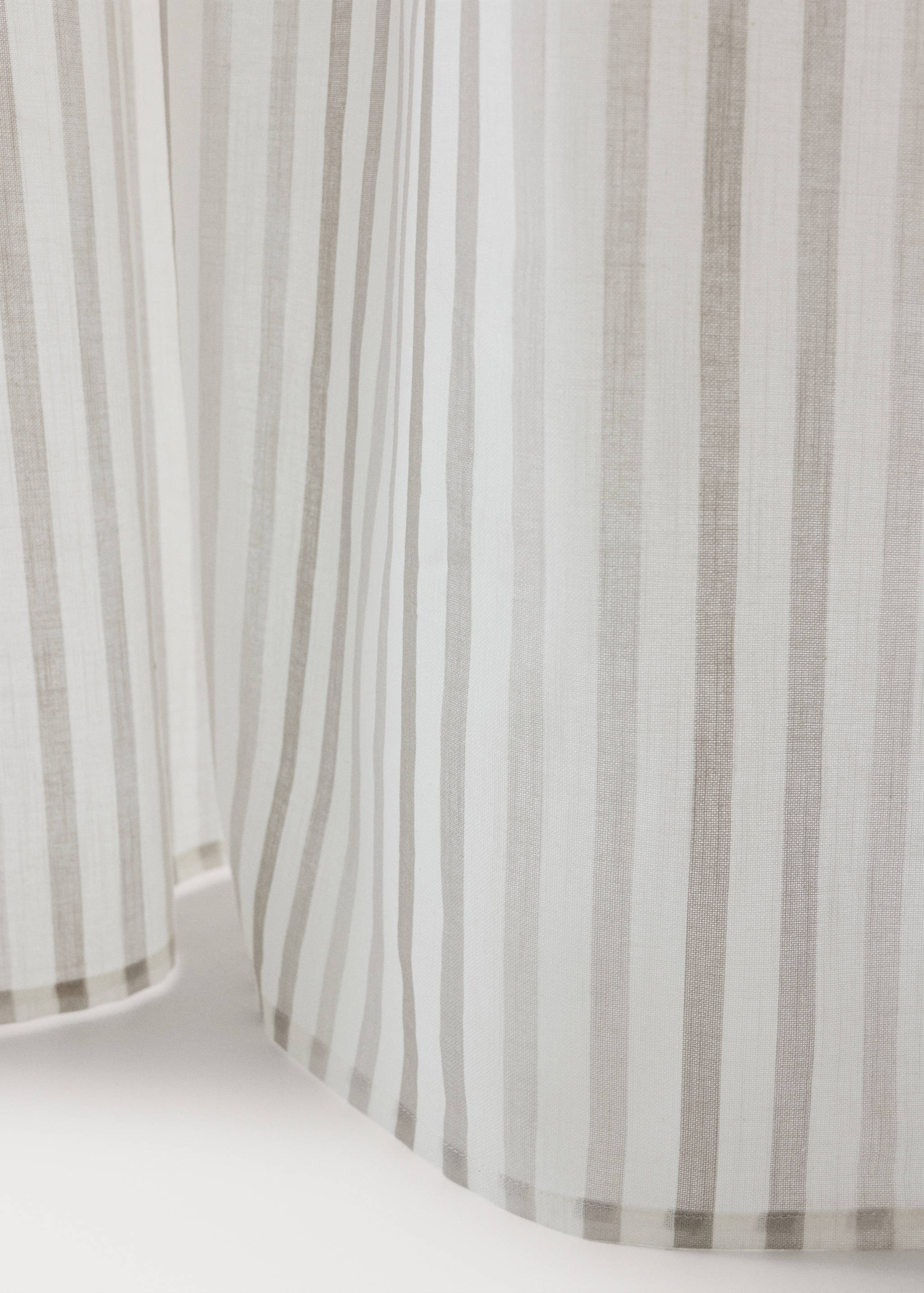 Striped curtain with vertical grey and white patterns.