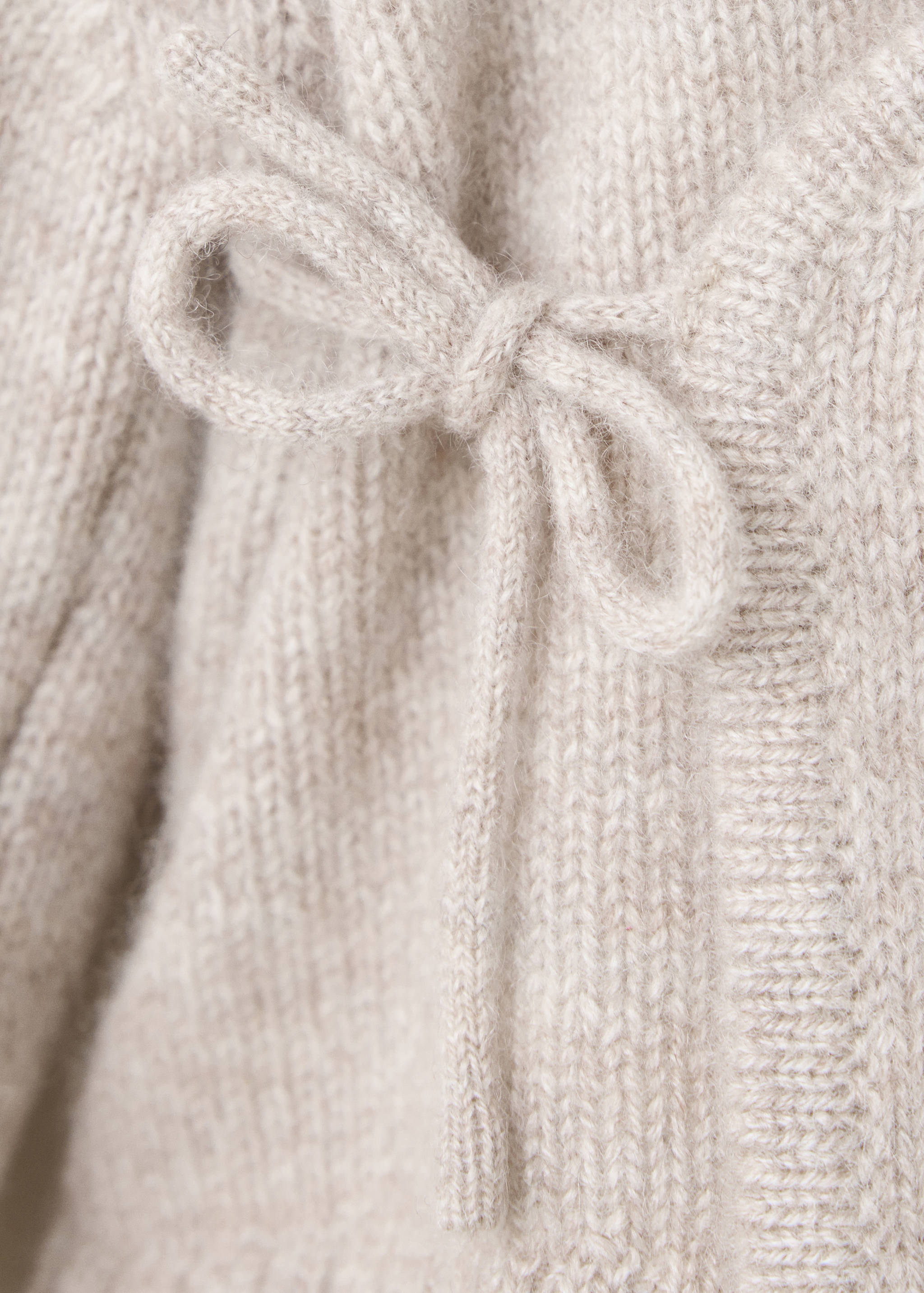 Beige knit jersey detail showing a side tie bow