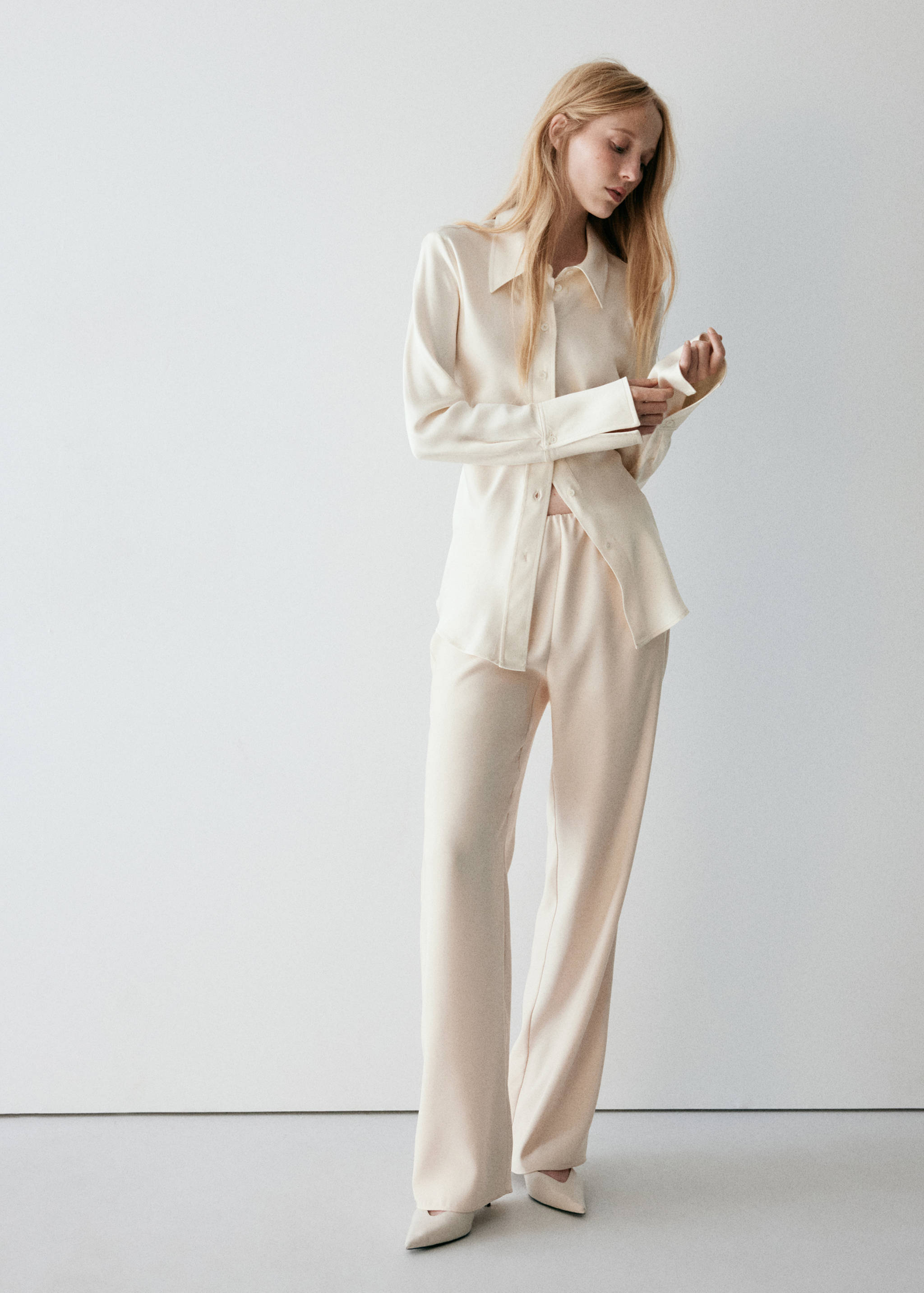 Ecru trousers with a relaxed straight-leg fit, worn with a matching shirt.