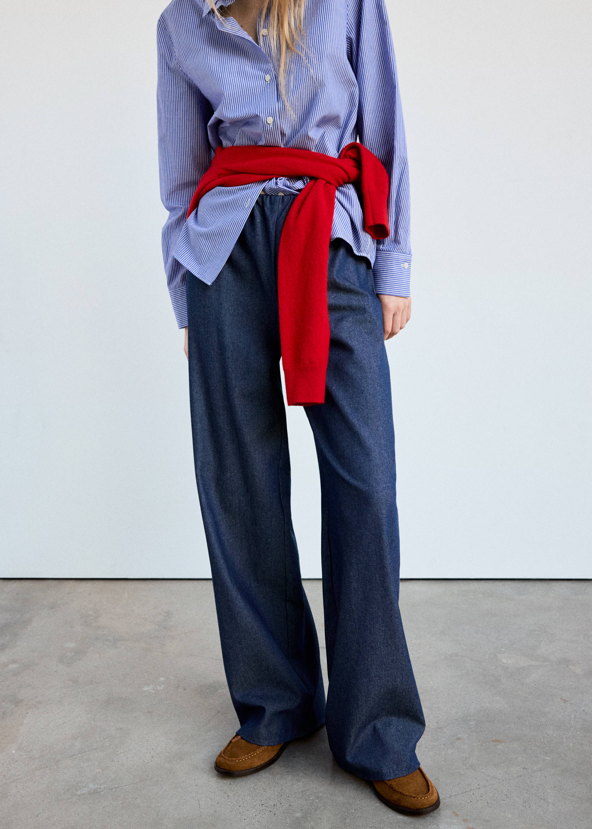 Dark blue denim trousers with a loose, straight-leg silhouette and an elasticated waistband.