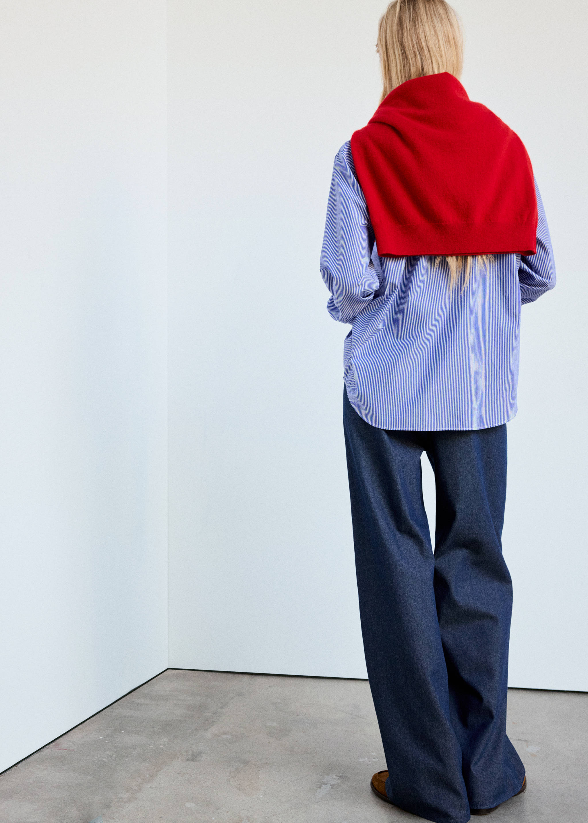 Dark blue trousers seen from behind, worn with a striped shirt.