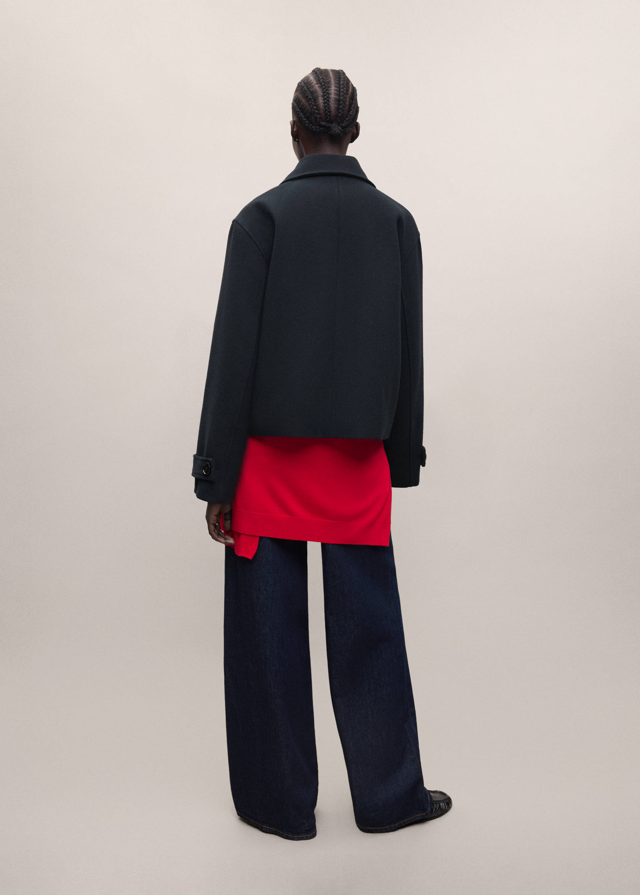 Black cropped coat with lapel collar and cuff tabs, shown from the back.