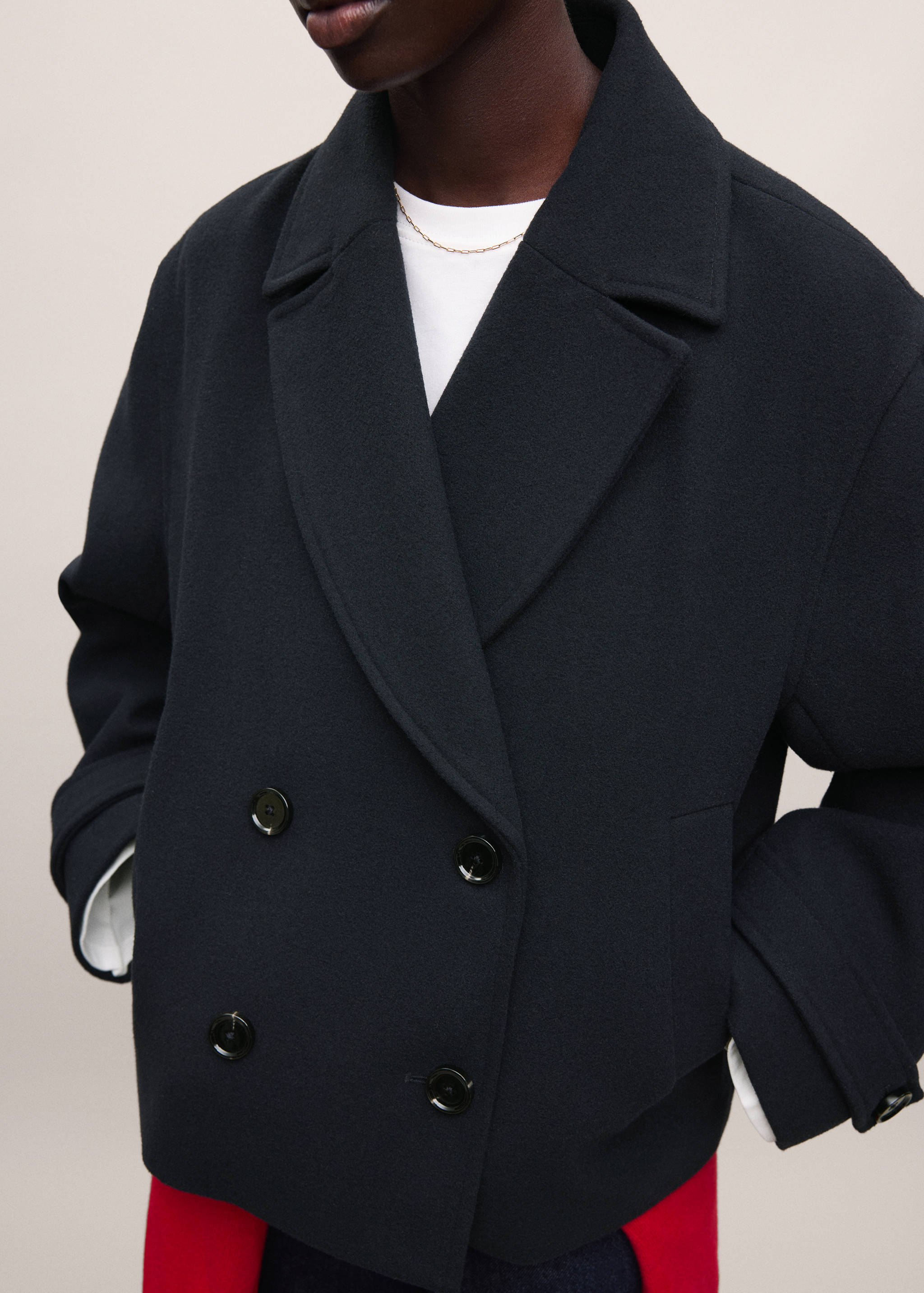 Black double-breasted coat with wide lapels and round buttons.