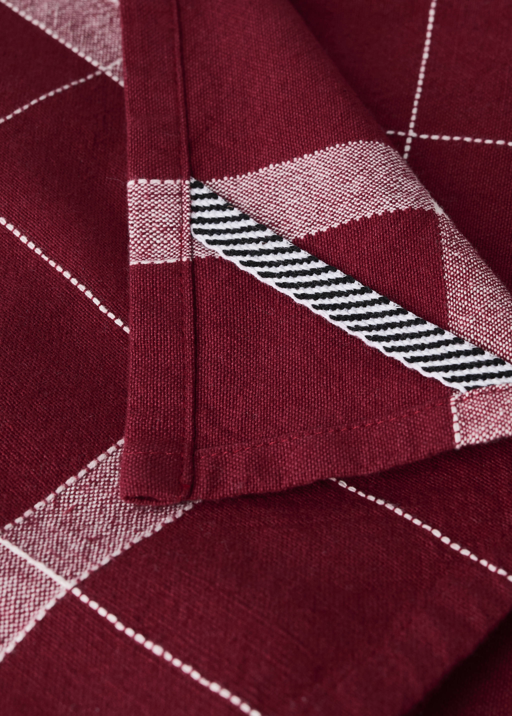 Burgundy kitchen tea towel with white grid pattern and striped trim detail.