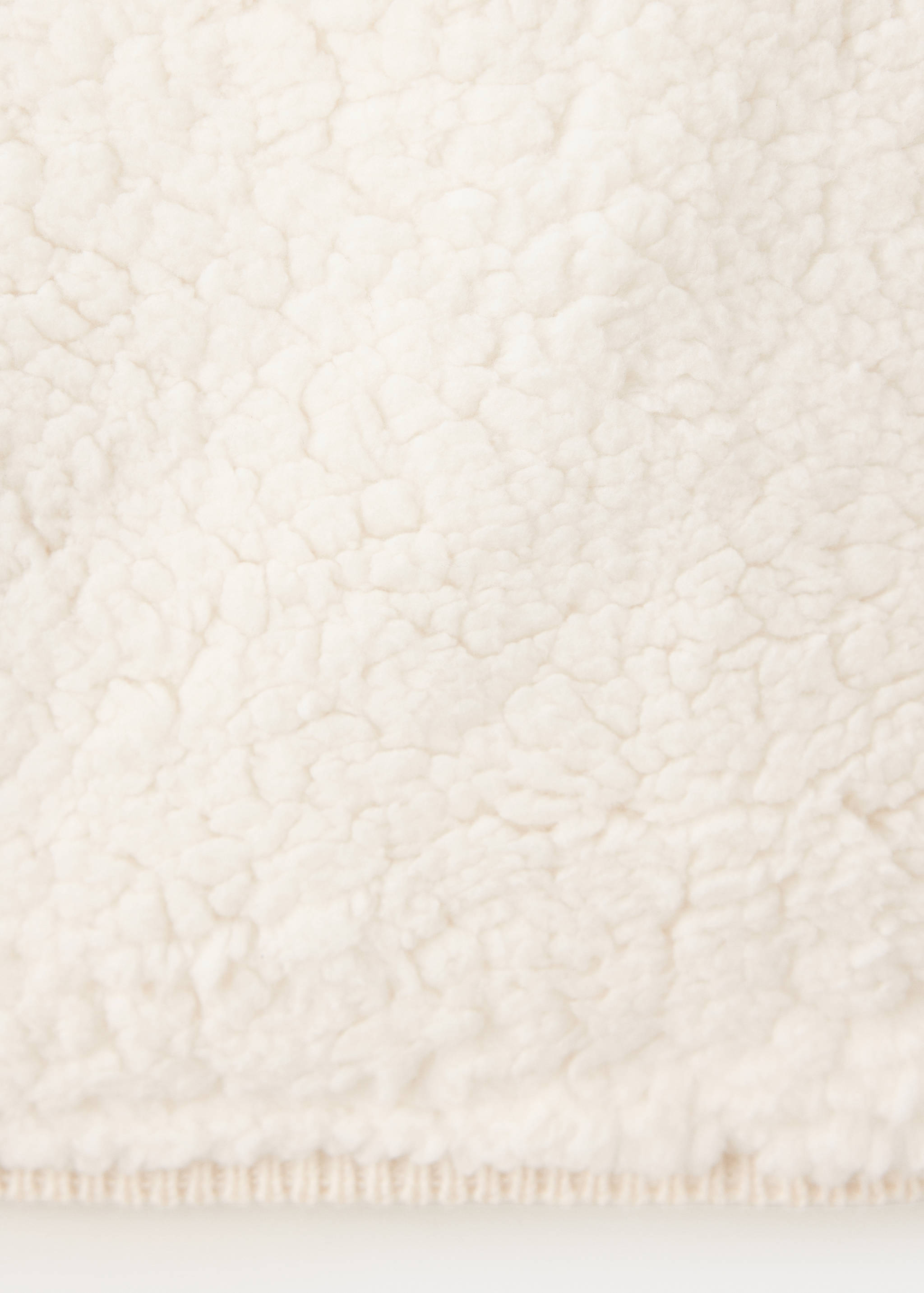 Close-up of a cream kids cardigan featuring soft faux-shearling texture.