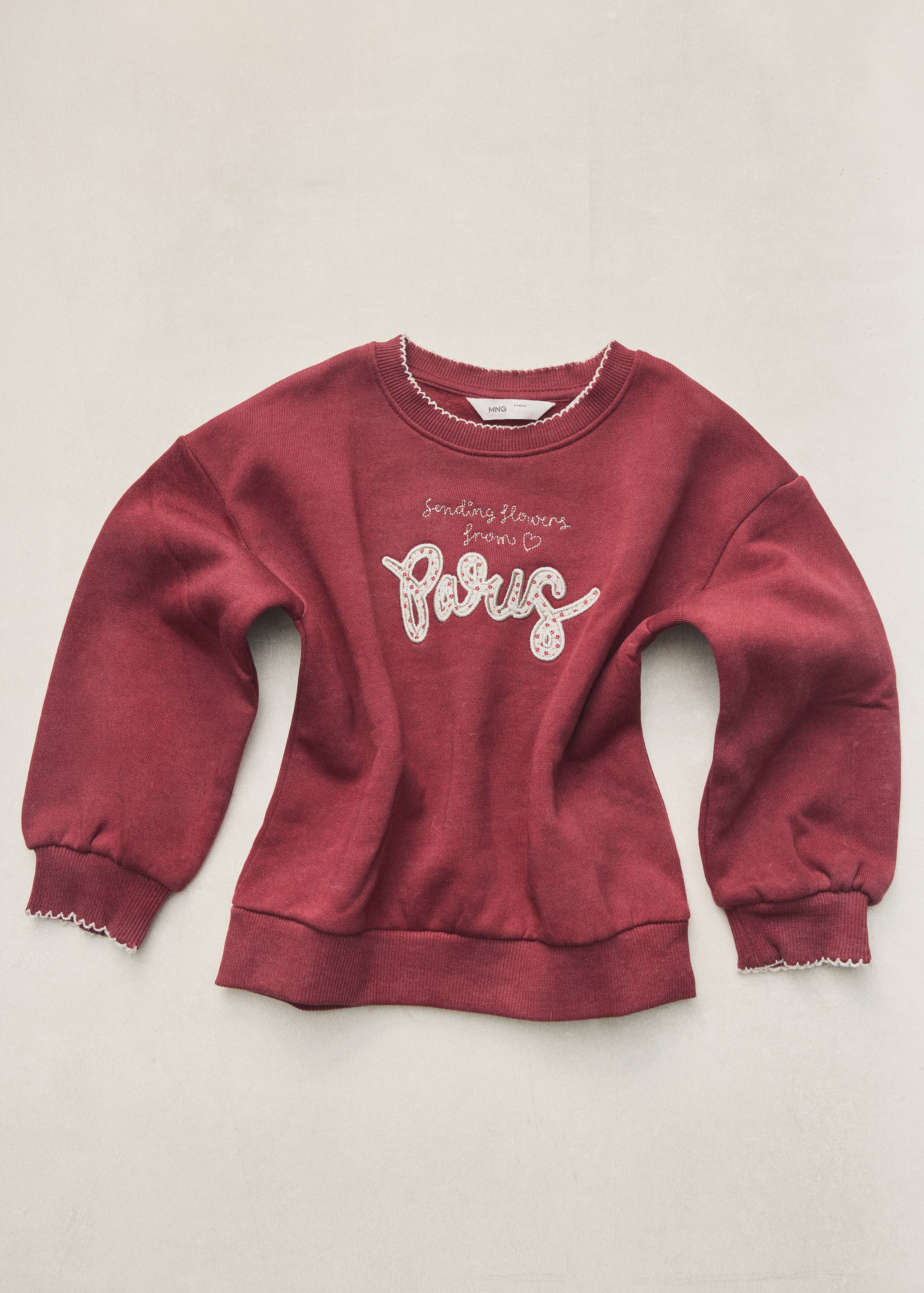 Dark red children's sweatshirt with white embroidered slogan and scalloped trim.