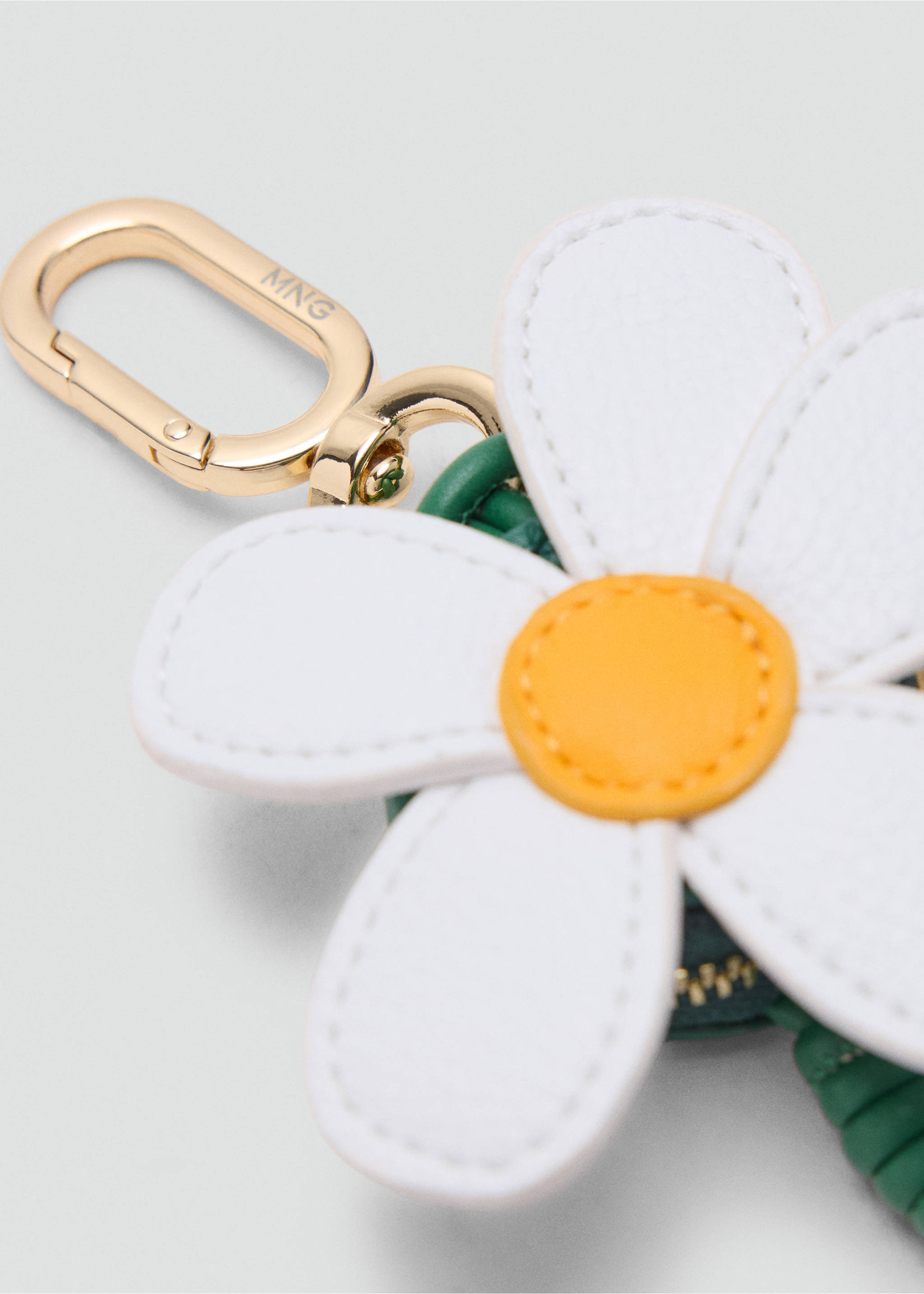 Close-up of a white and yellow daisy keychain with a gold-tone metal clasp., Off White. Ref: 37076747-00.