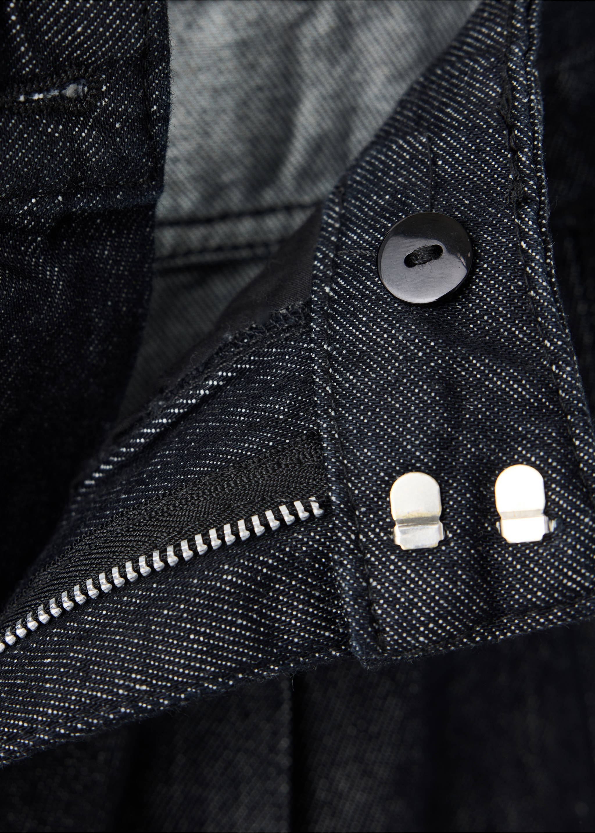 Close-up of dark denim trousers showing the button and zip fastening., Black. Ref: 37076748-00.