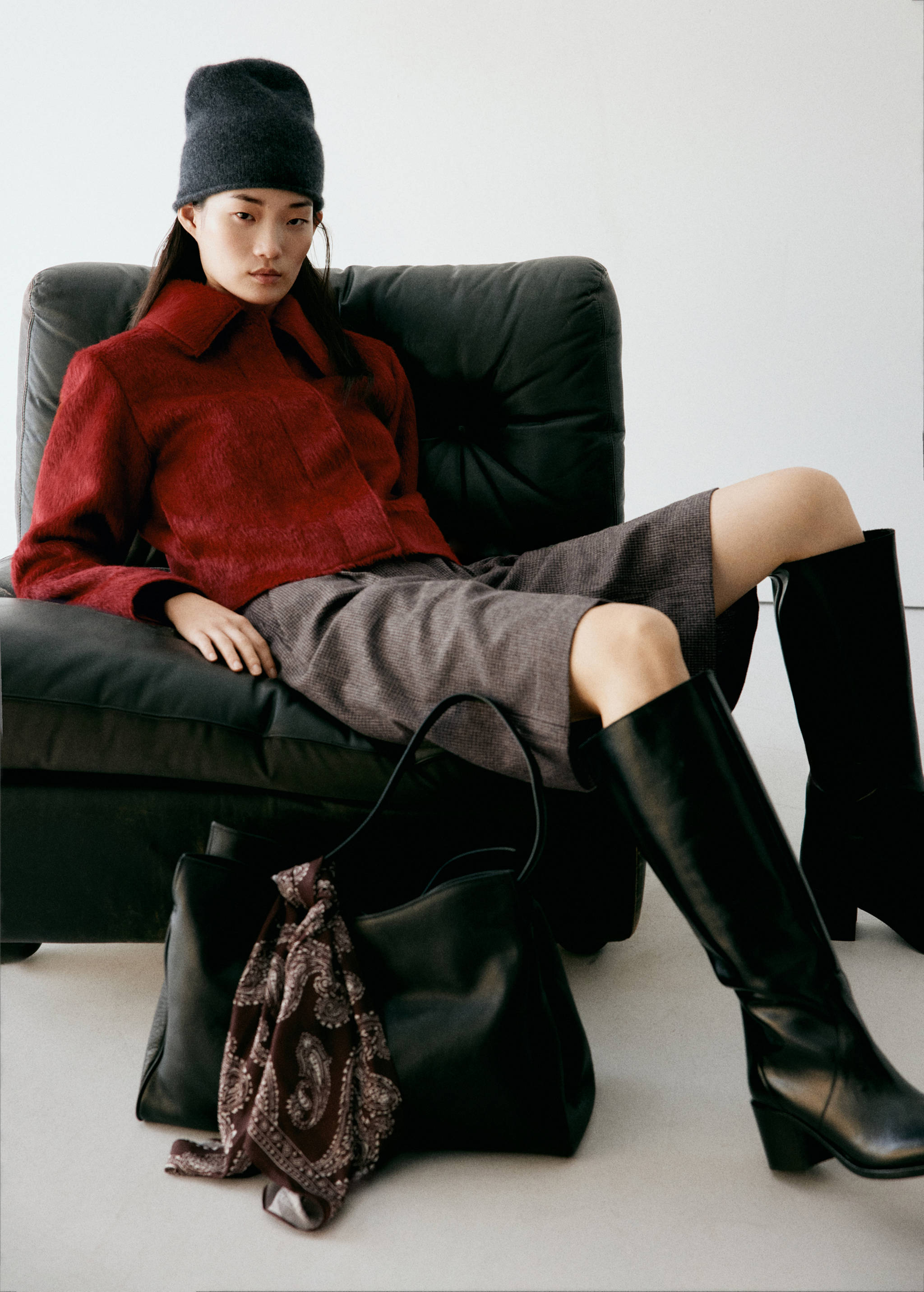 Dark red textured jacket with a classic collar, worn by a seated model.