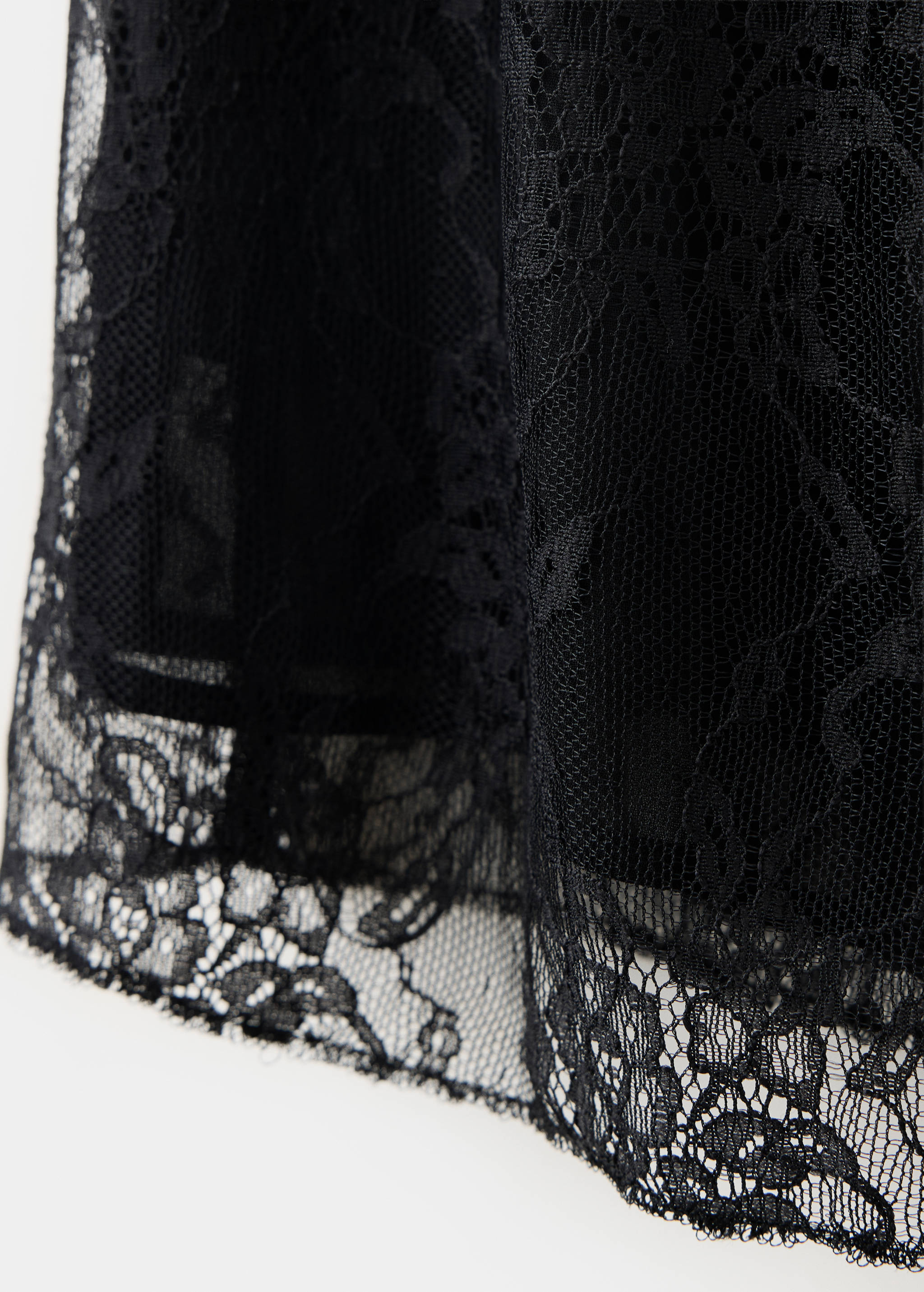 Close-up of black lace top showing the fabric texture and pattern.