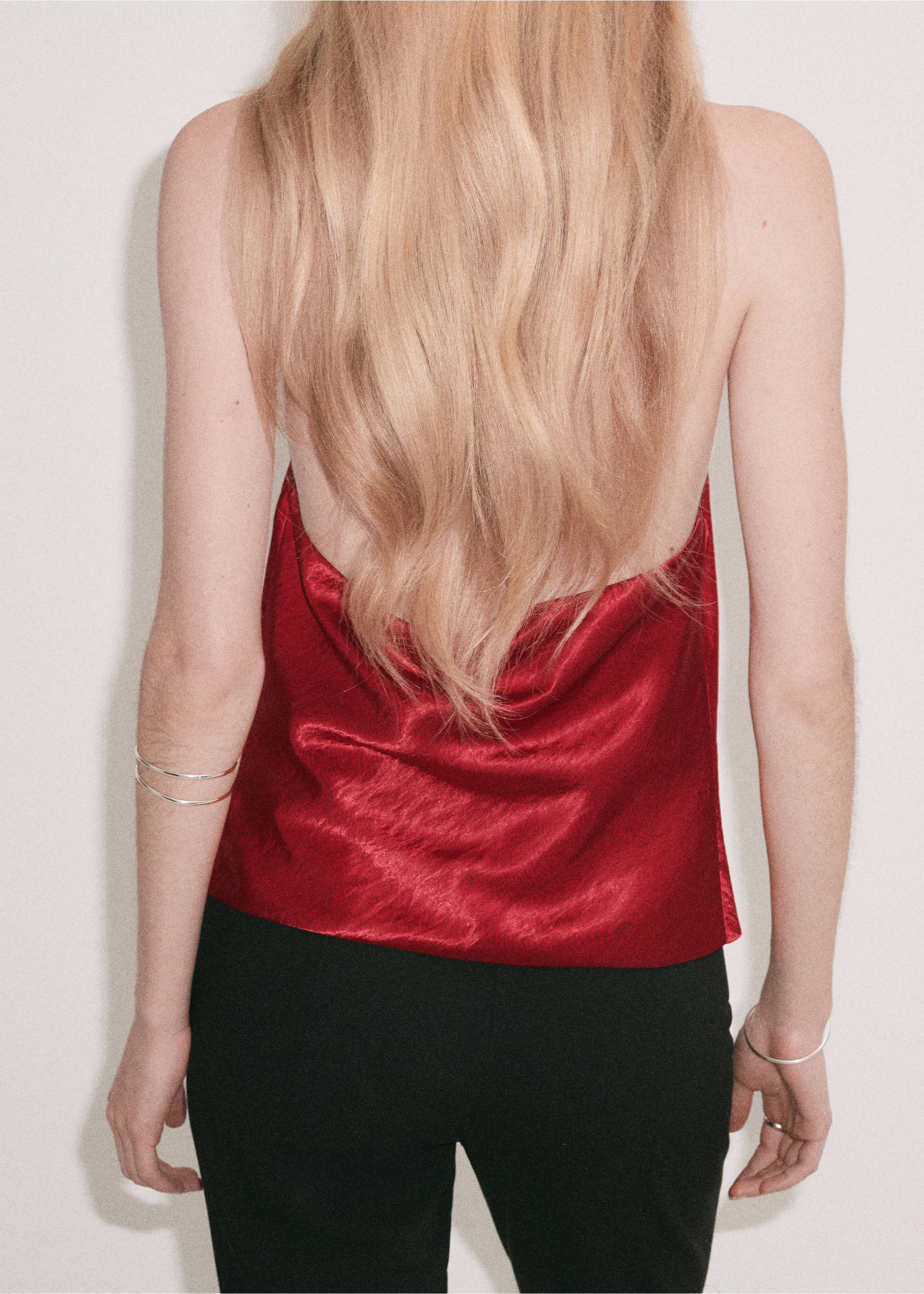 Back view of a red satin halter top worn with black trousers., Red. Ref: 37077780-00.